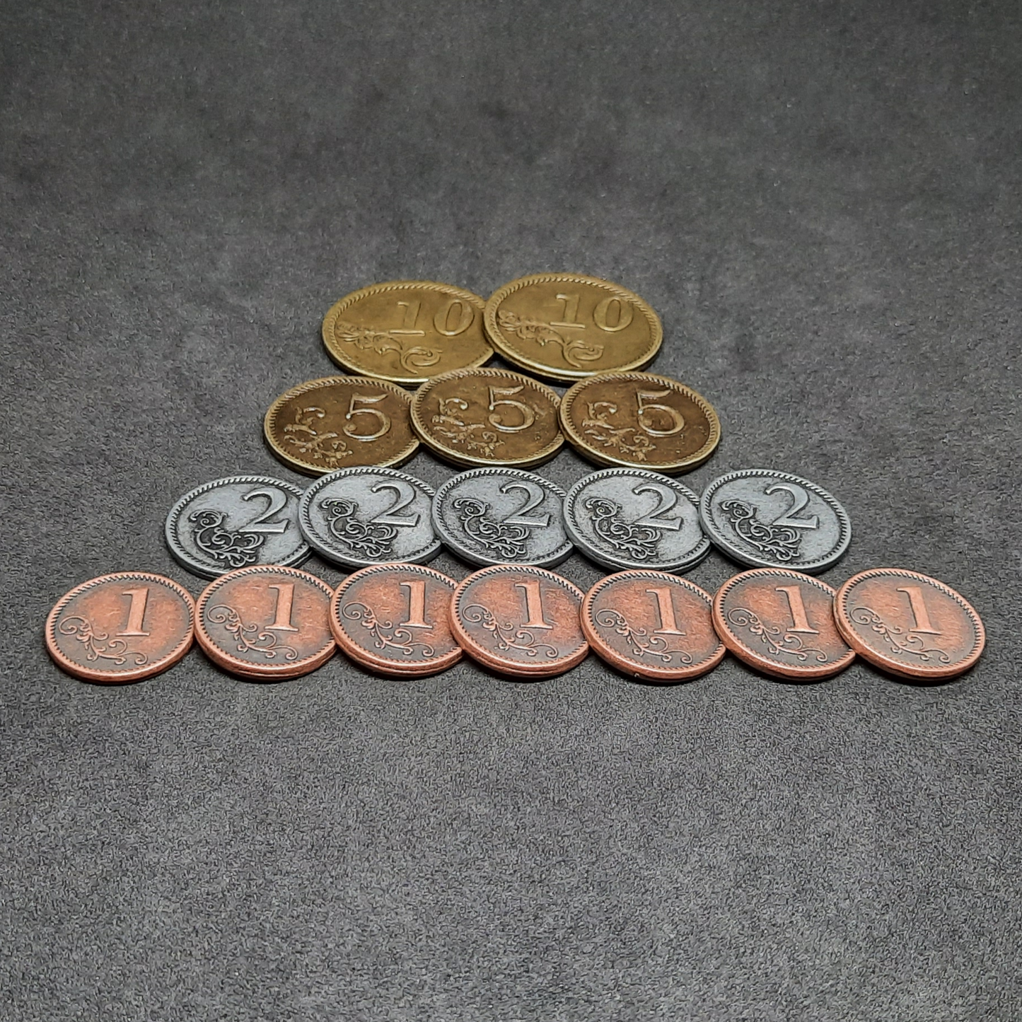 Set of bronze, silver and gold metal coins of value 1, 2, 5 and 10 for board games