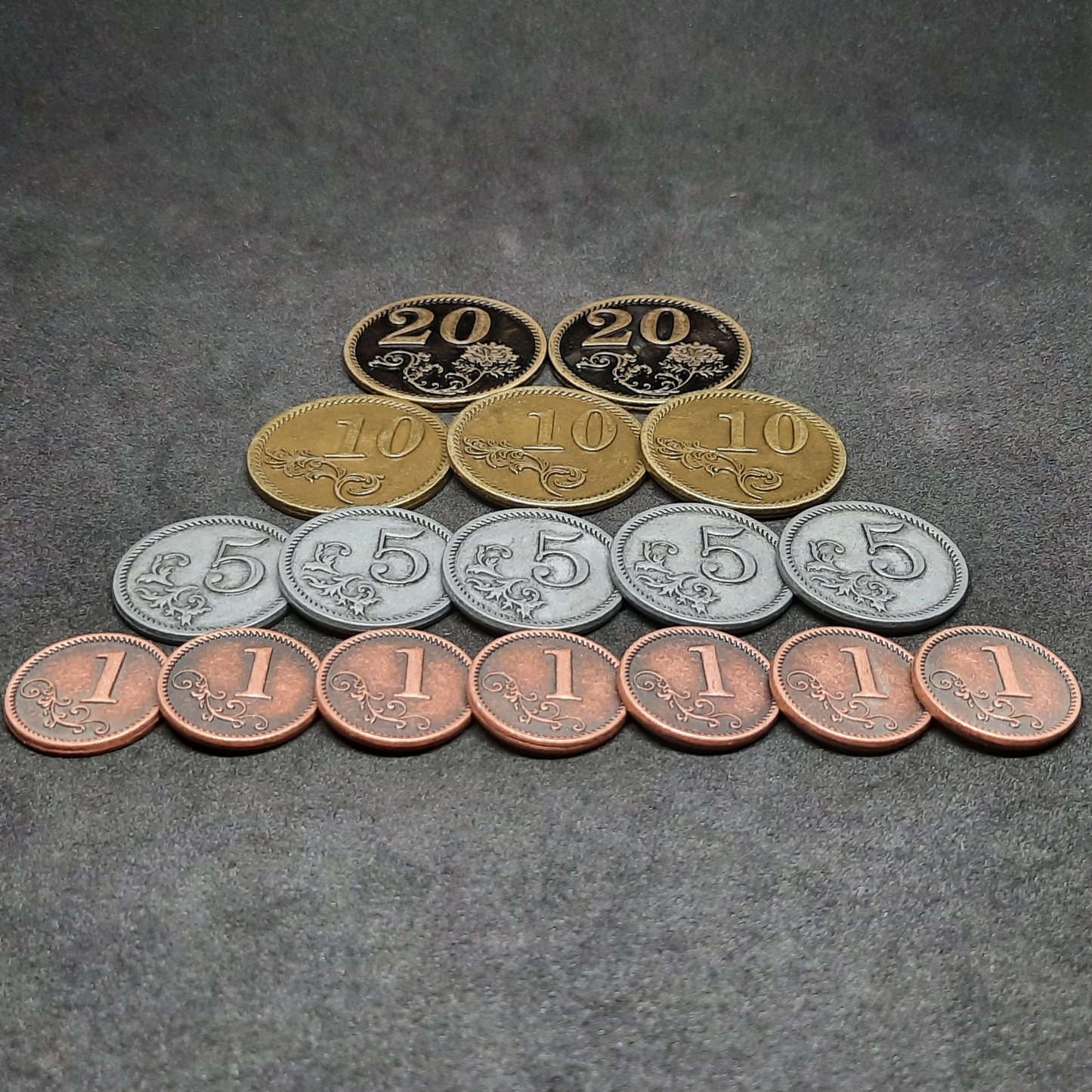 Set of bronze, silver and gold metal coins of value 1, 5, 10 and 20 for board games