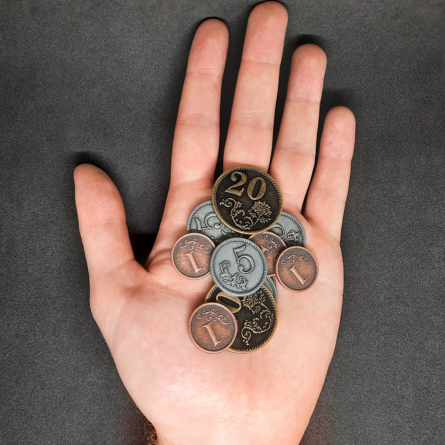 Set of bronze, silver and gold metal coins of value 1, 5 and 20 for board games