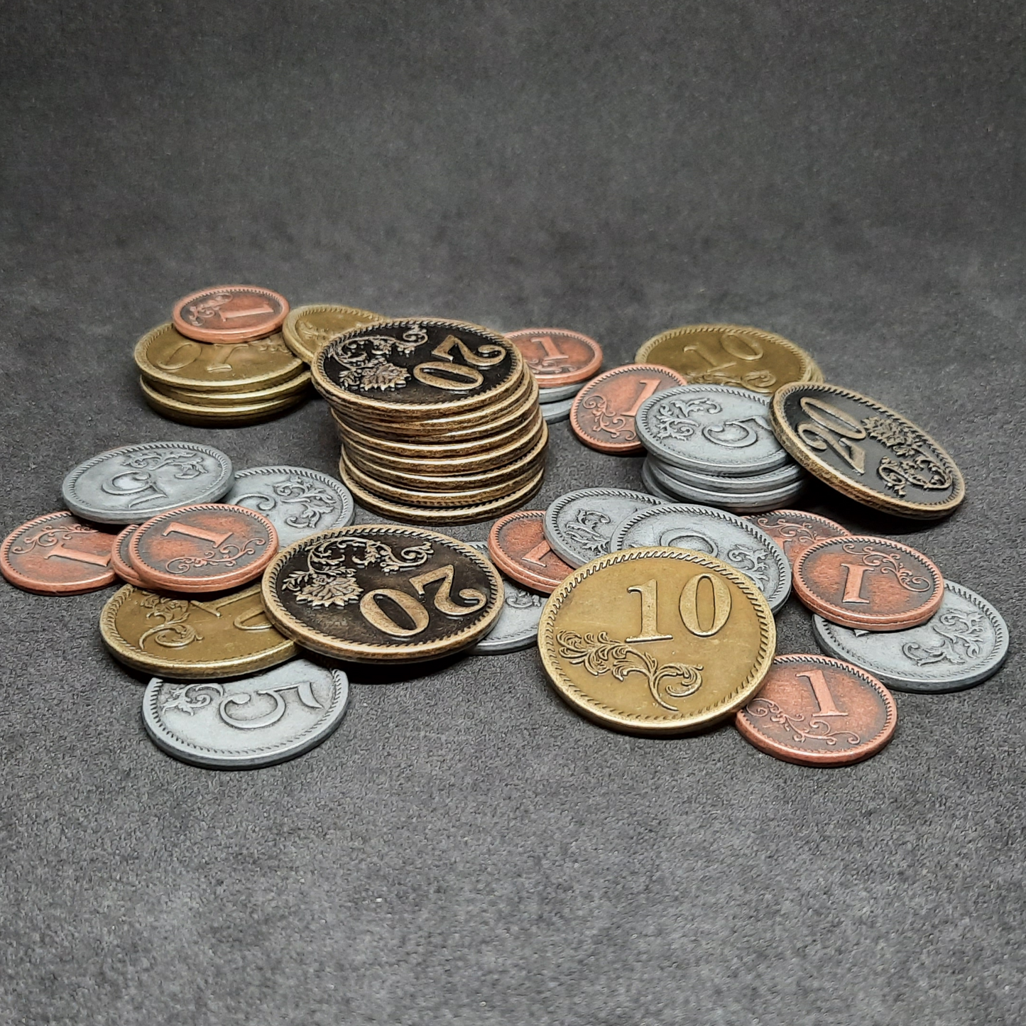 Set of bronze, silver and gold metal coins of value 1, 5, 10 and 20 for board games