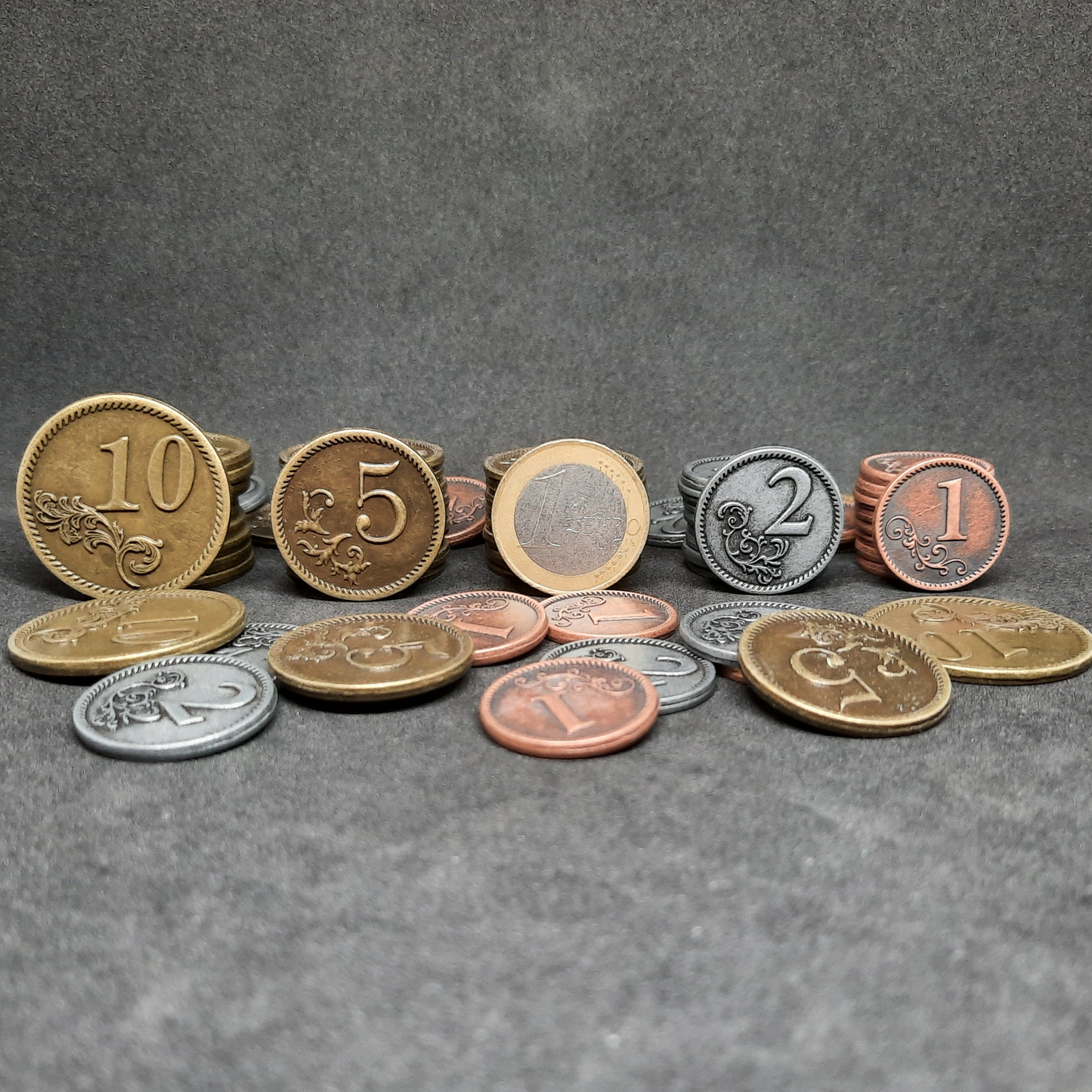 Set of bronze, silver and gold metal coins of value 1, 2, 5 and 10 for board games