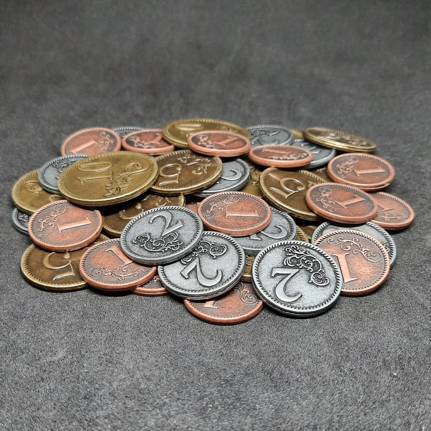 Set of bronze, silver and gold metal coins of value 1, 2, 5 and 10 for board games