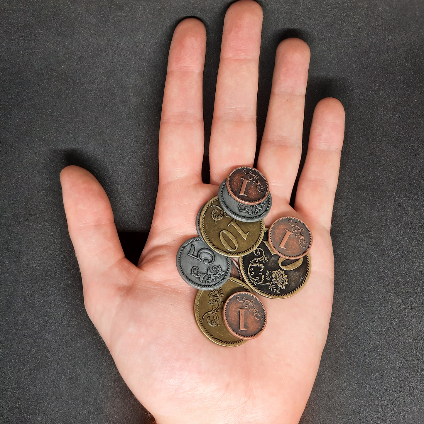 Set of bronze, silver and gold metal coins of value 1, 5, 10 and 20 for board games