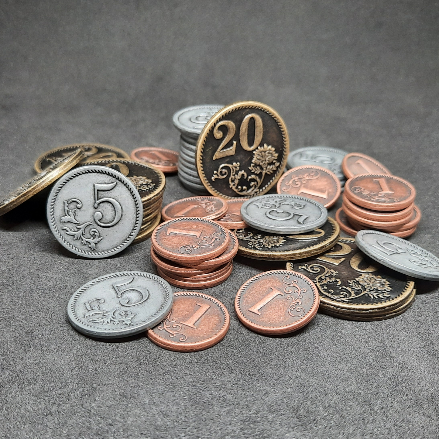 Set of bronze, silver and gold metal coins of value 1, 5 and 20 for board games