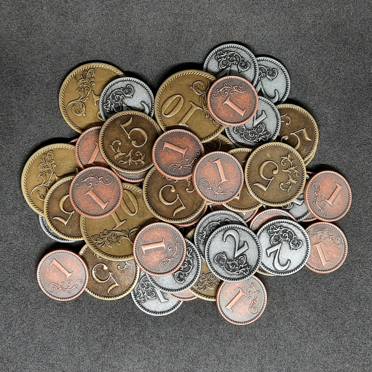 Set of bronze, silver and gold metal coins of value 1, 2, 5 and 10 for board games