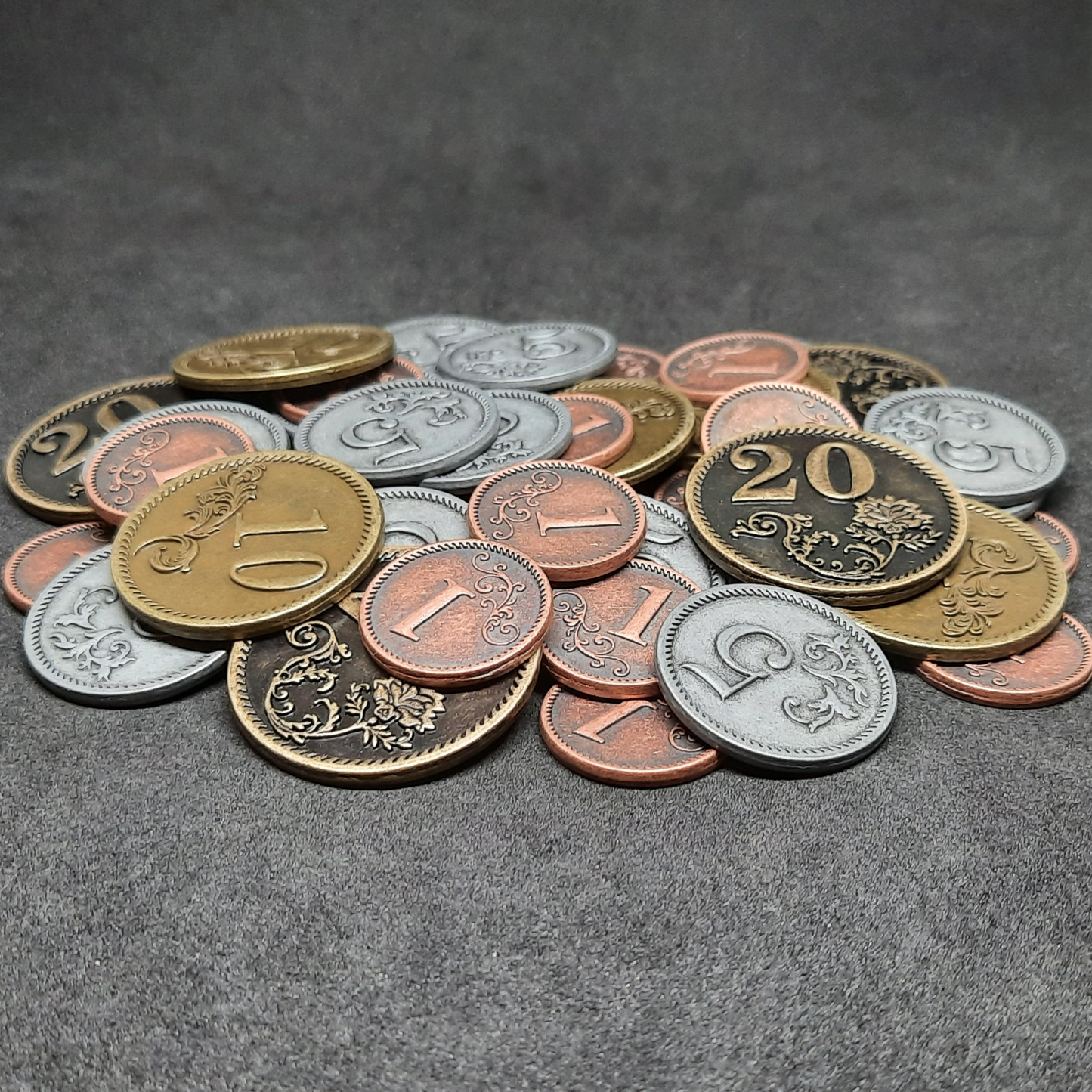 Set of bronze, silver and gold metal coins of value 1, 5, 10 and 20 for board games