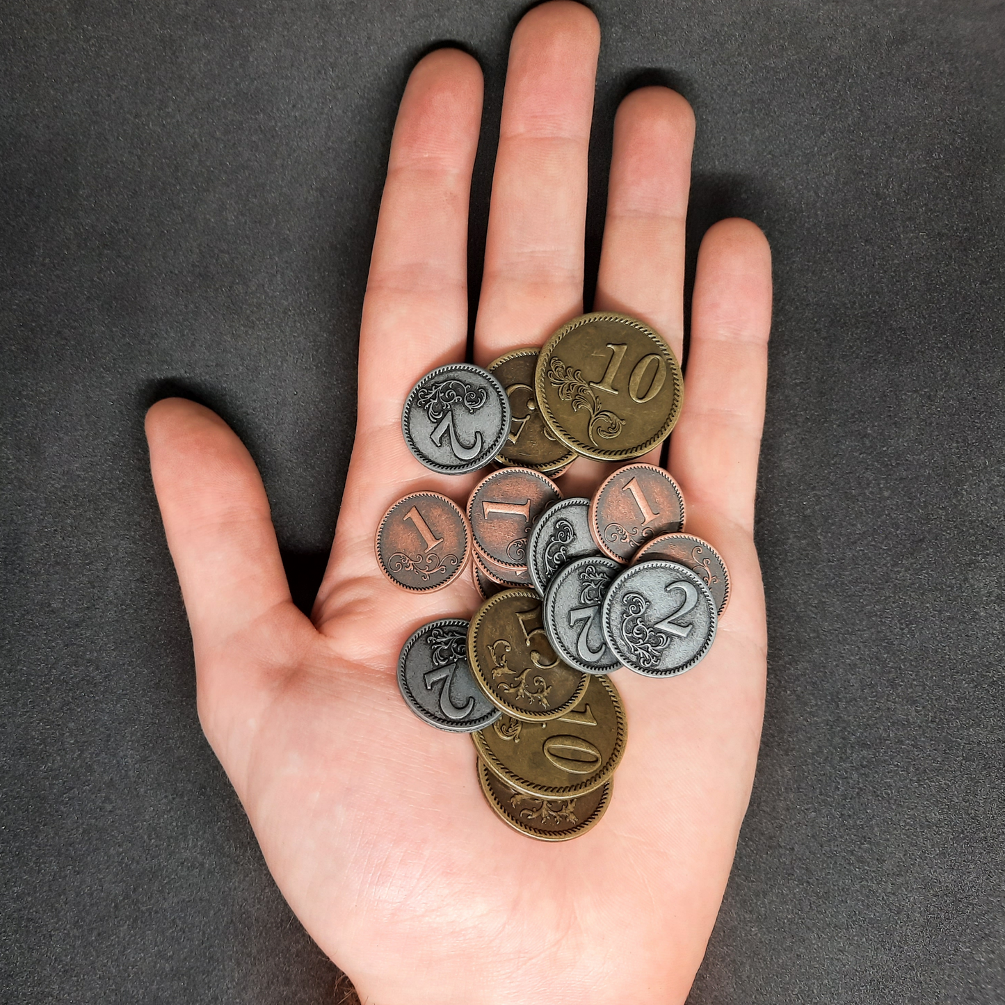 Set of bronze, silver and gold metal coins of value 1, 2, 5 and 10 for board games