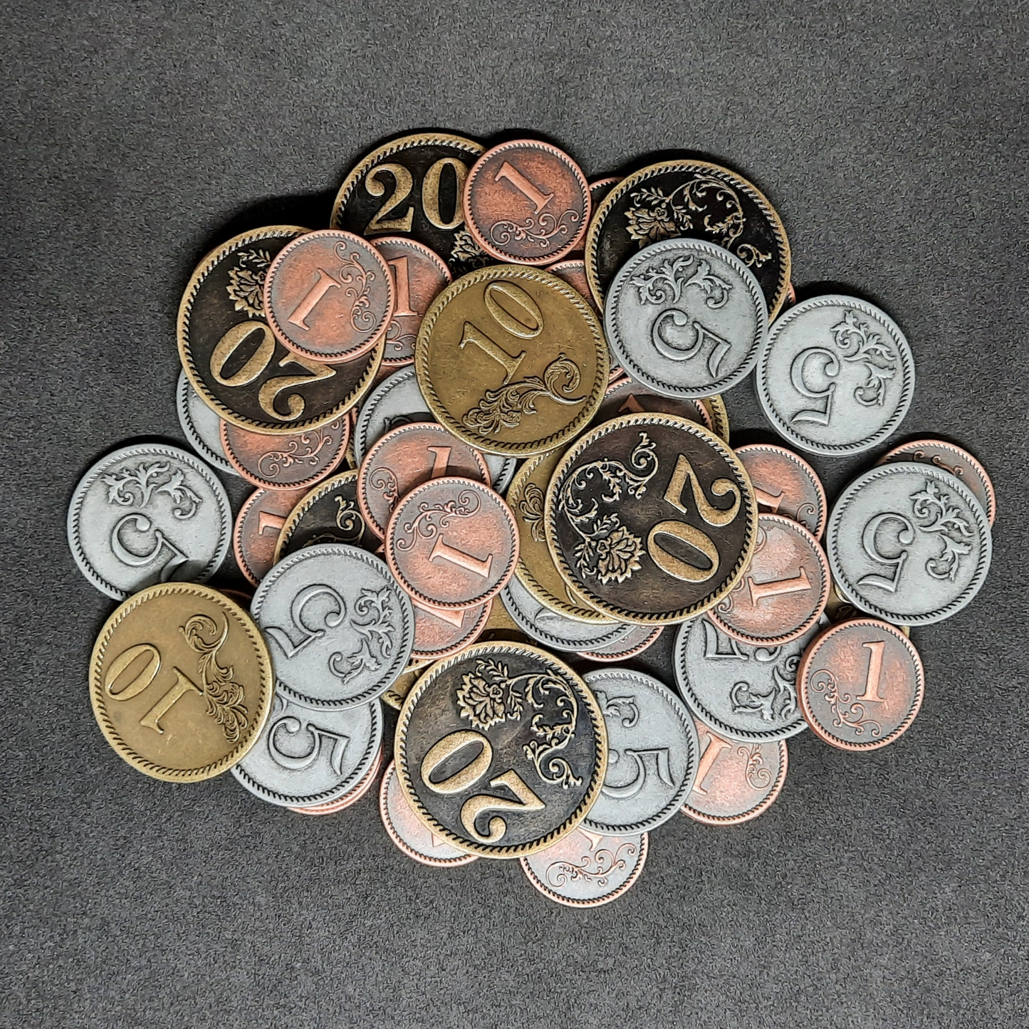 Set of bronze, silver and gold metal coins of value 1, 5, 10 and 20 for board games