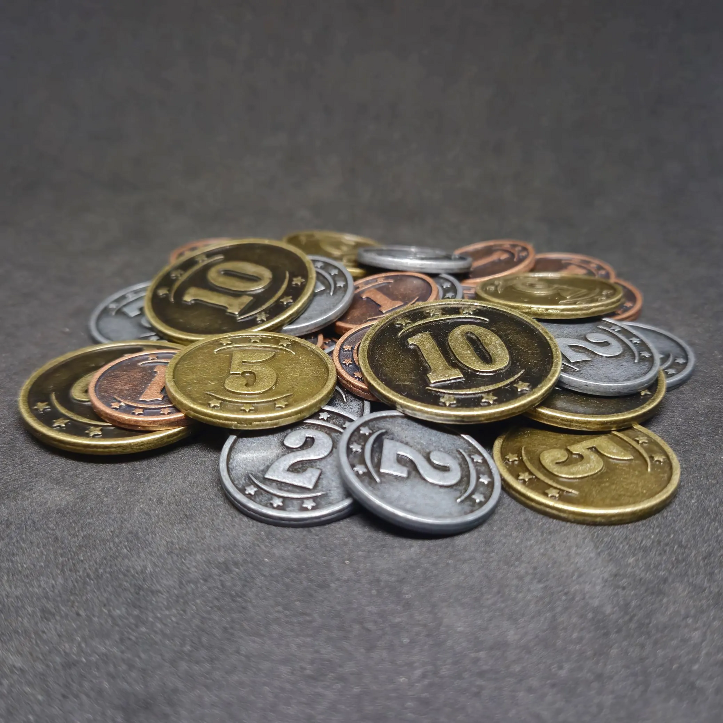 Set of bronze, silver and gold western metal coins of value 1, 2, 5 and 10 for board games