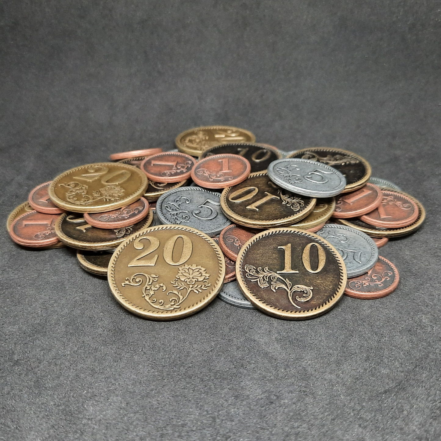 Set of bronze, silver and gold metal coins of value 1, 5, 10 and 20 for board games