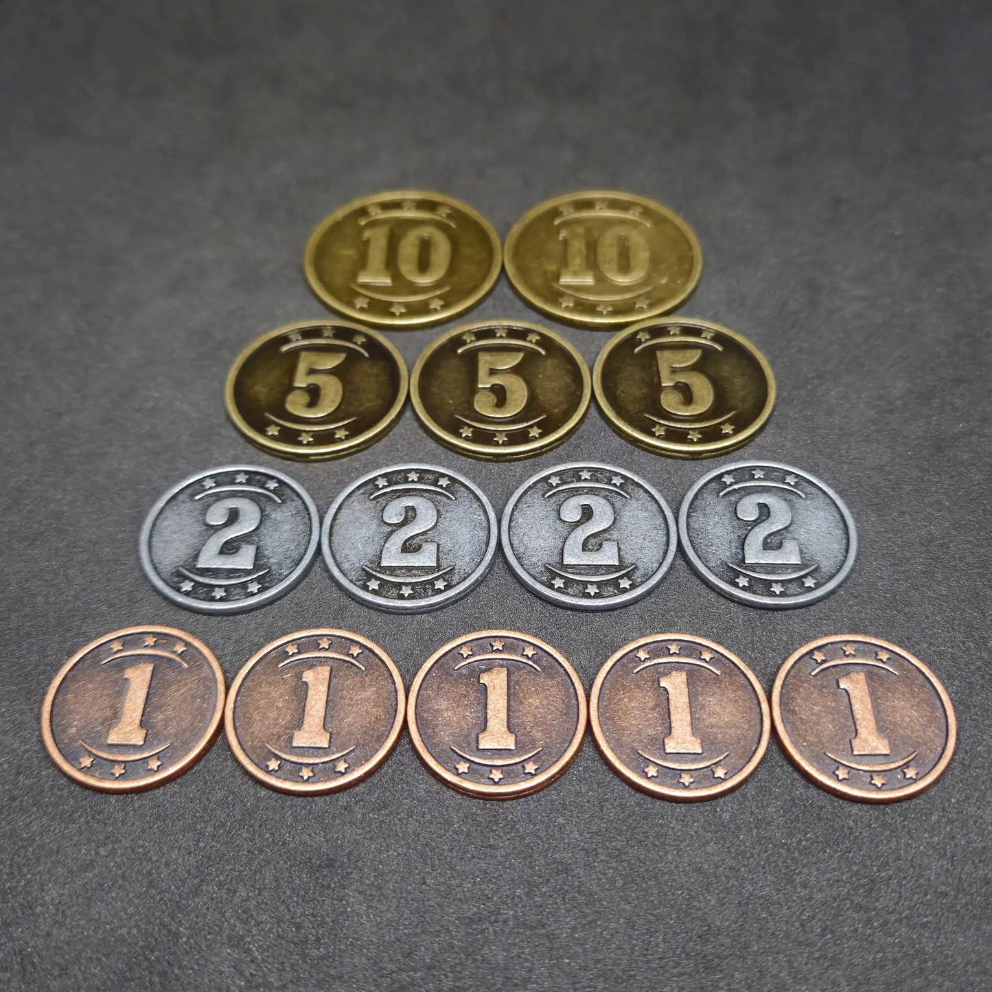 Set of bronze, silver and gold western metal coins of value 1, 2, 5 and 10 for board games