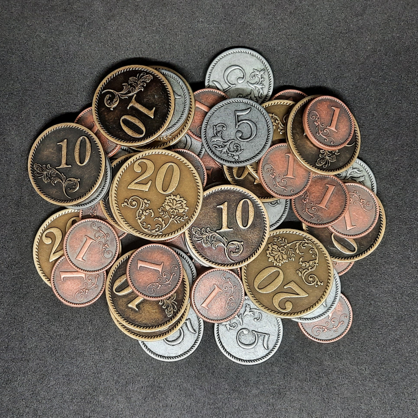 Set of bronze, silver and gold metal coins of value 1, 5, 10 and 20 for board games