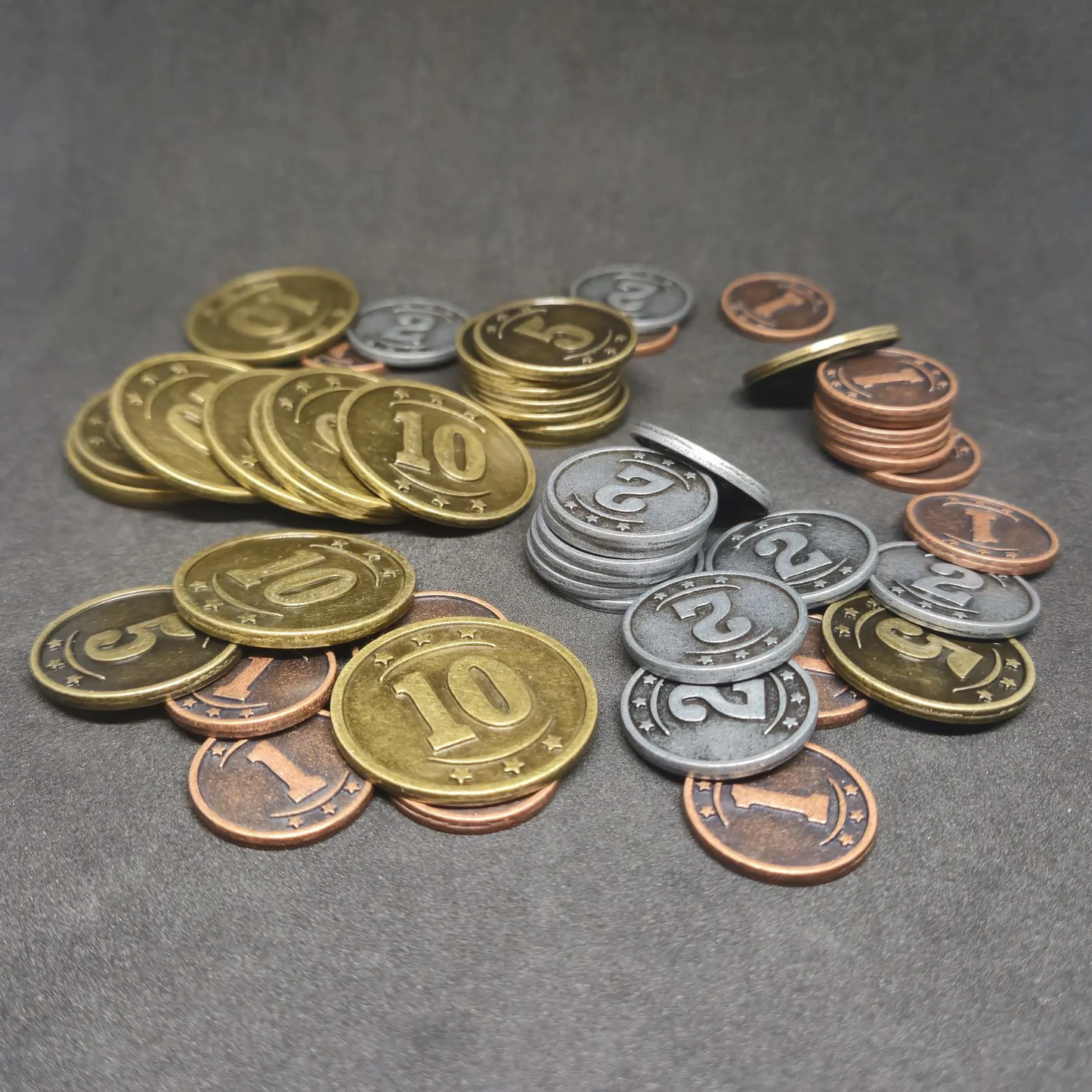 Set of bronze, silver and gold western metal coins of value 1, 2, 5 and 10 for board games