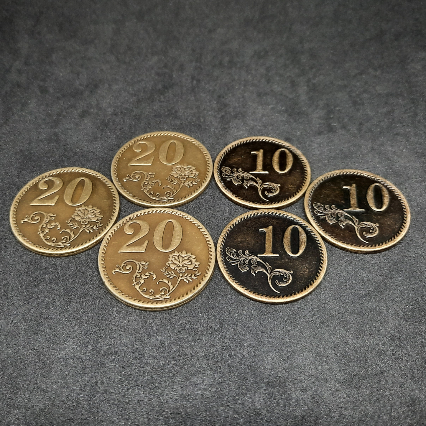 Set of bronze, silver and gold metal coins of value 1, 5, 10 and 20 for board games