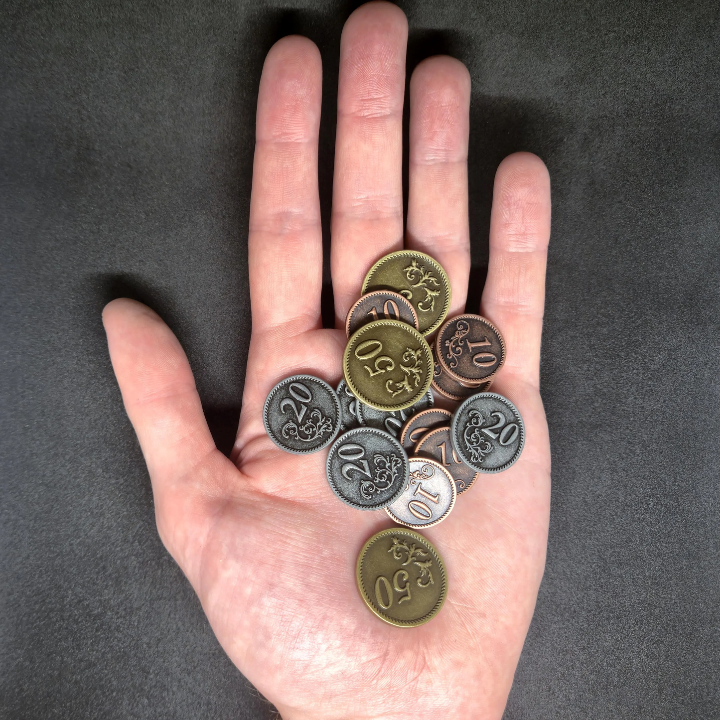 Set of bronze, silver and gold metal coins of value 10, 20, and 50 for board games
