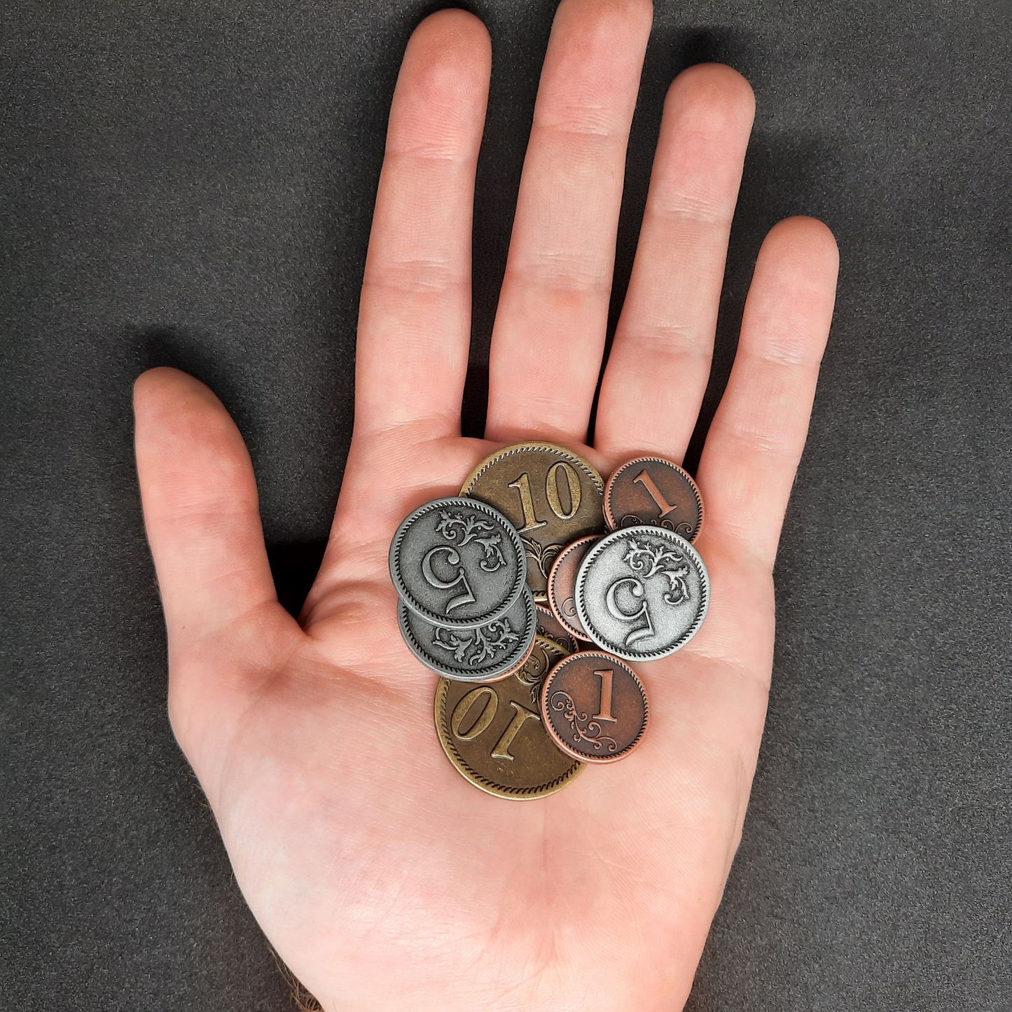 Set of bronze, silver and gold metal coins of value 1, 5 and 10 for board games