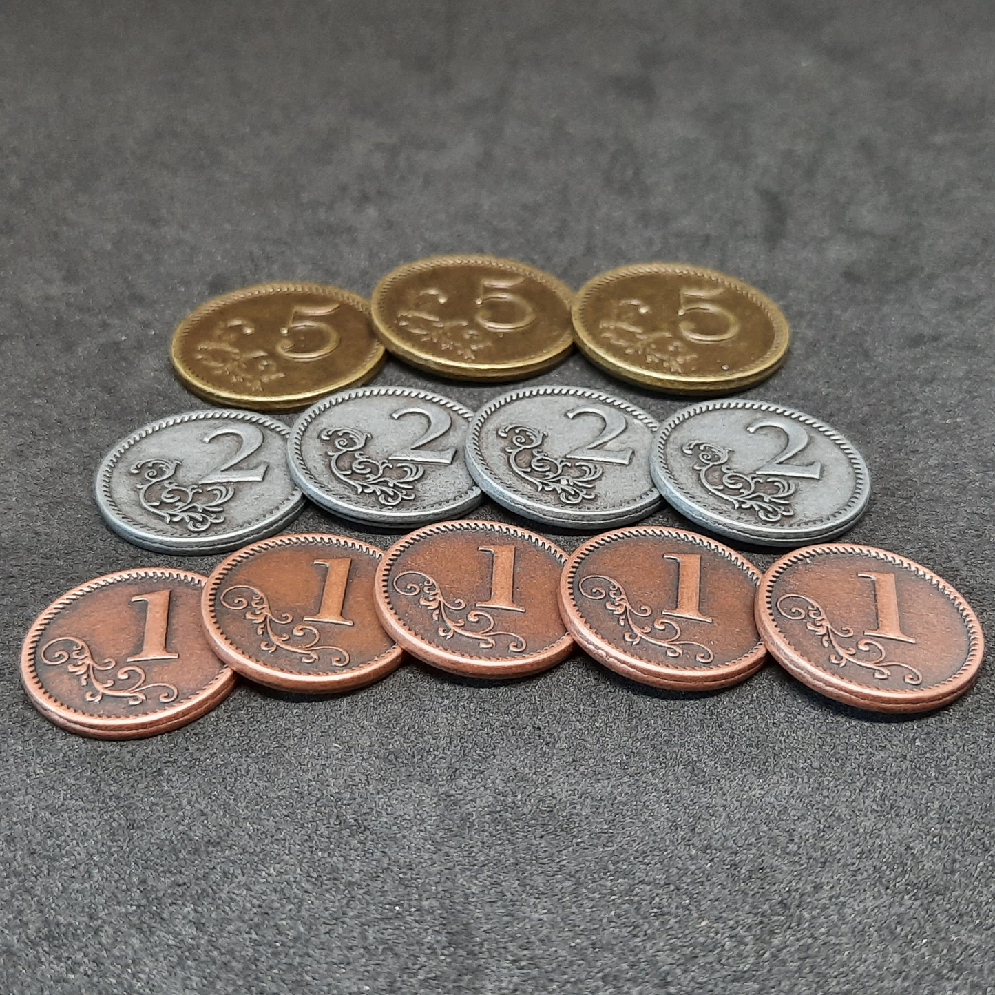 Set of bronze, silver and gold metal coins of value 1, 2 and 5 for board games