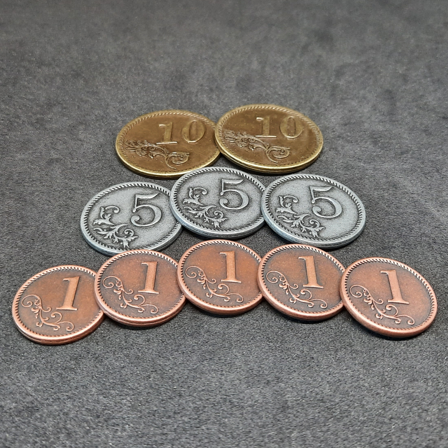 Set of bronze, silver and gold metal coins of value 1, 5 and 10 for board games