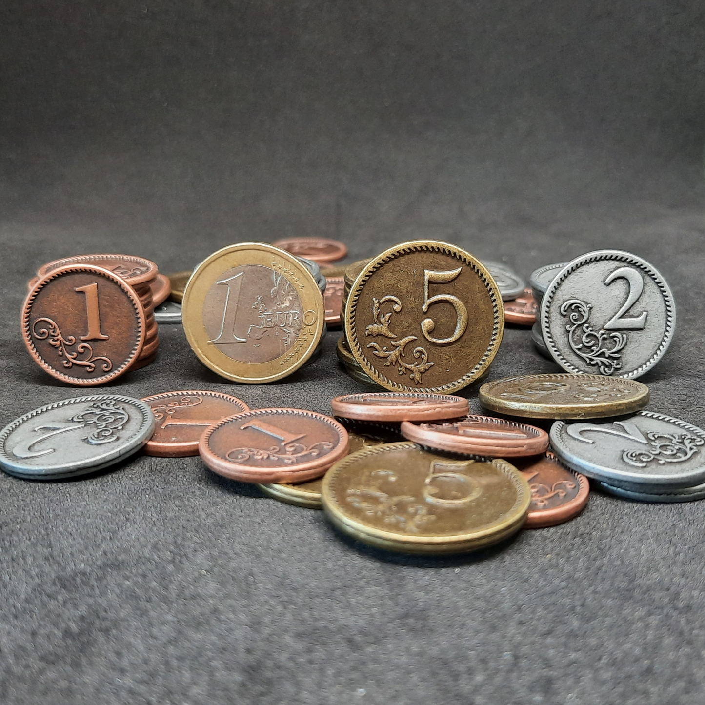 Set of bronze, silver and gold metal coins of value 1, 2 and 5 for board games