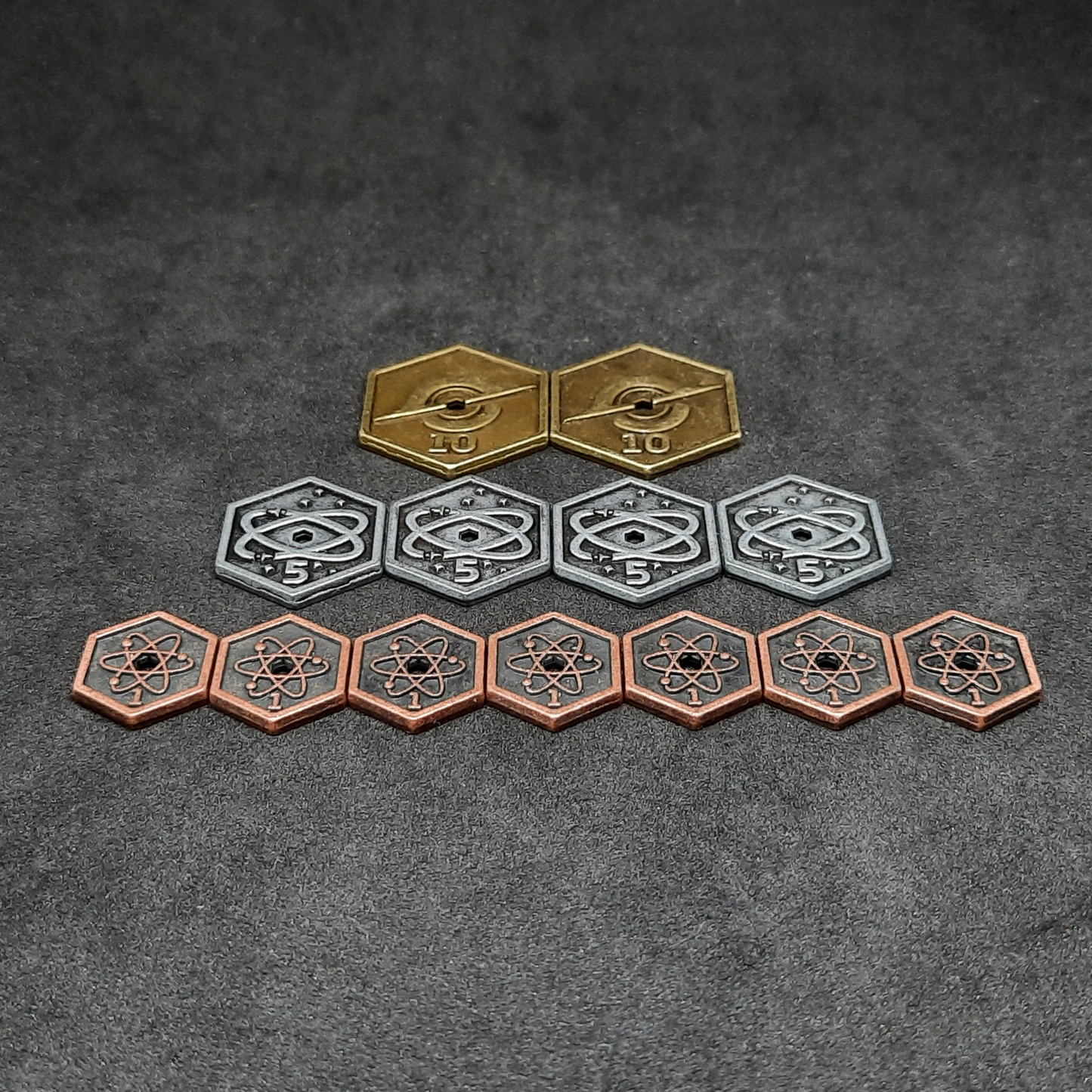 Set of spatial metal coins of value 1, 5 and 10 for board games, hexagonal shape