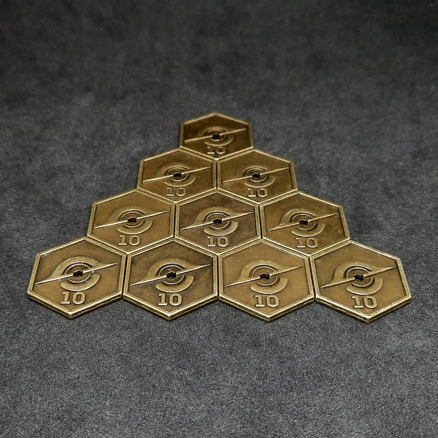 Gold spatial metal coins of value 10 for board games, hexagonal shape