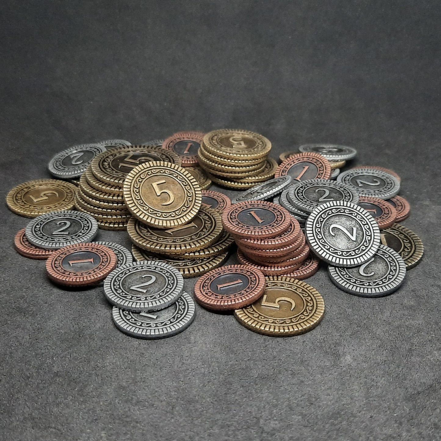 Set of bronze, silver and gold metal coins of value 1, 2, 5 and 15 for board games