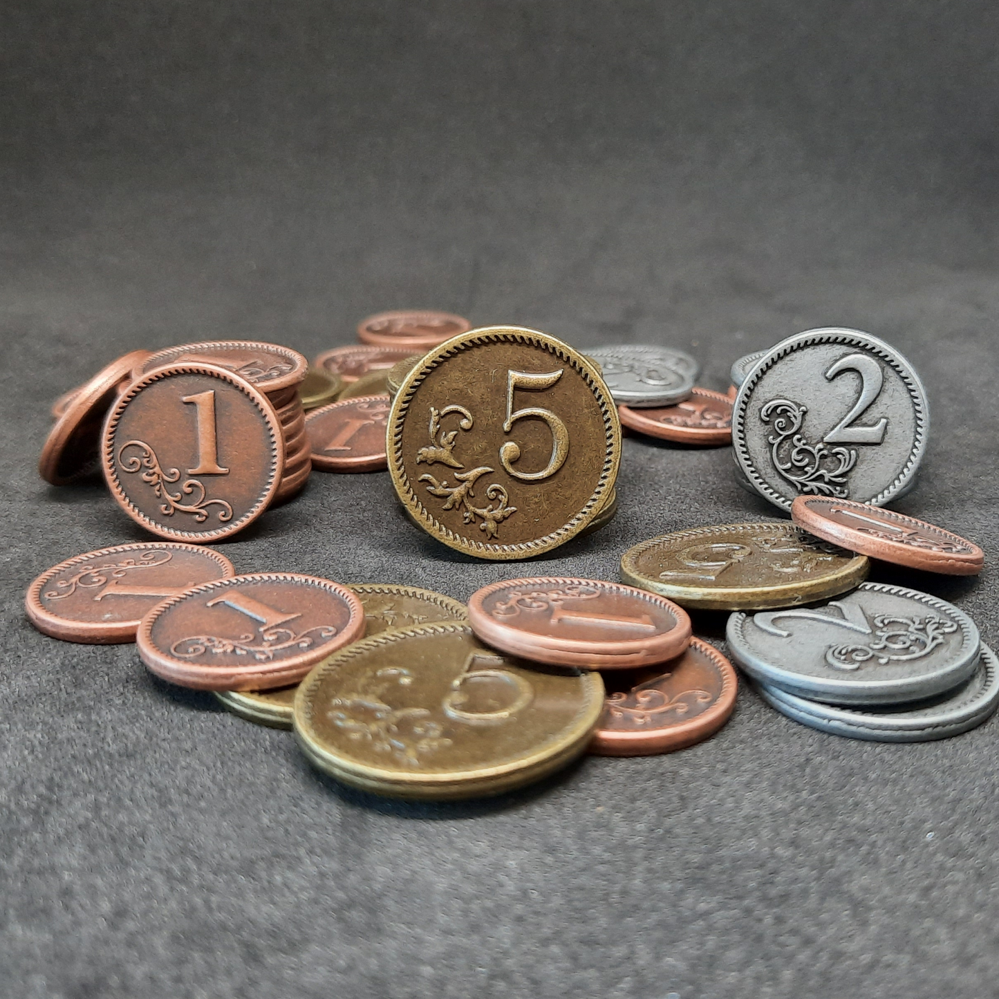 Set of bronze, silver and gold metal coins of value 1, 2 and 5 for board games