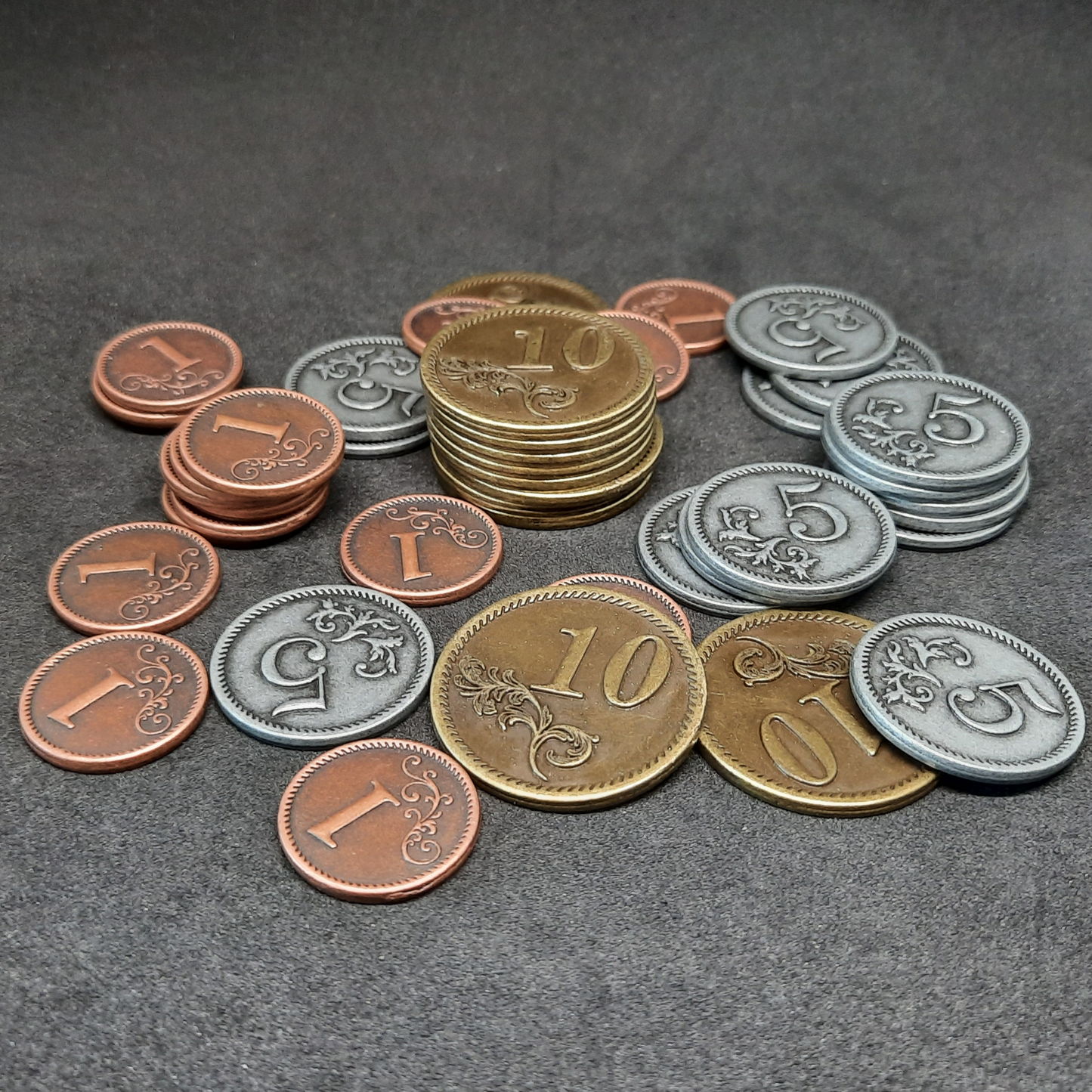 Set of bronze, silver and gold metal coins of value 1, 5 and 10 for board games