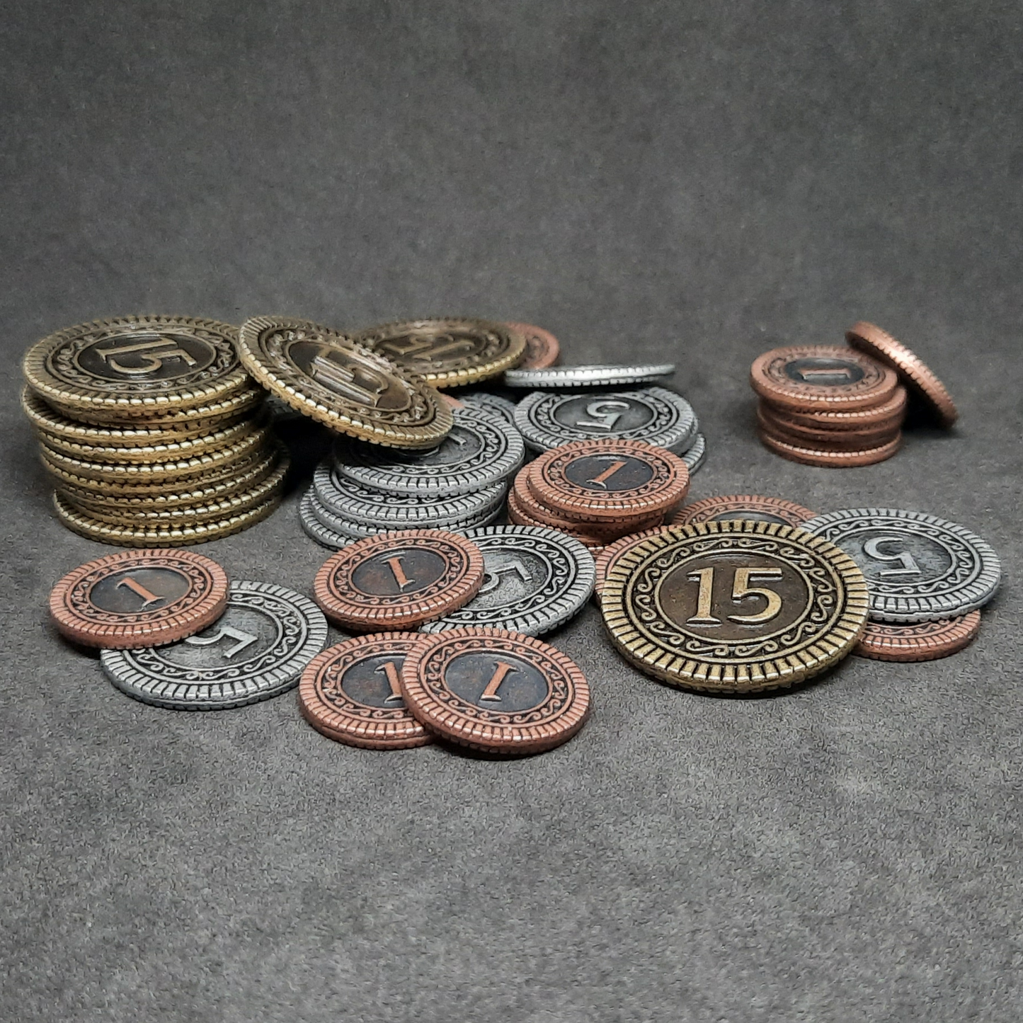 Set of bronze, silver and gold metal coins of value 1, 5 and 15 for board games