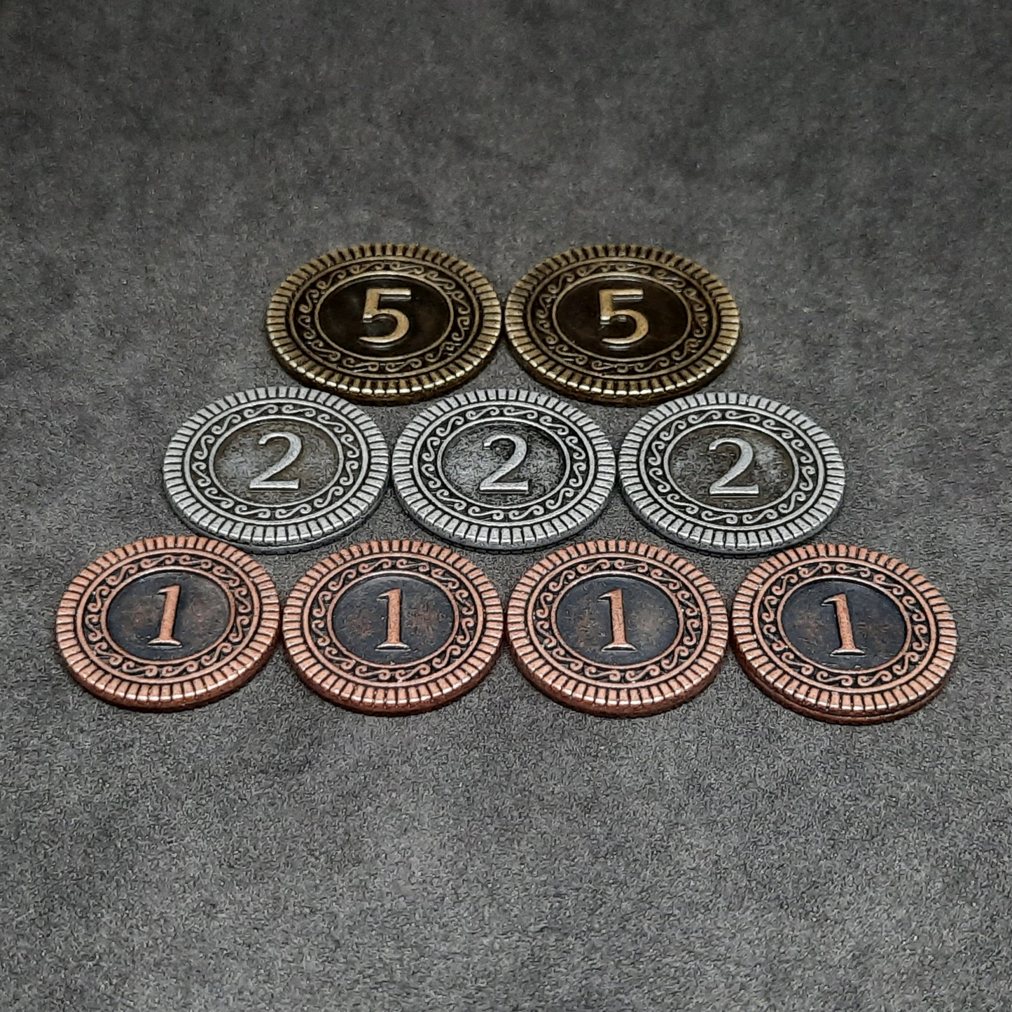 Set of bronze, silver and gold metal coins of value 1, 2 and 5 for board games