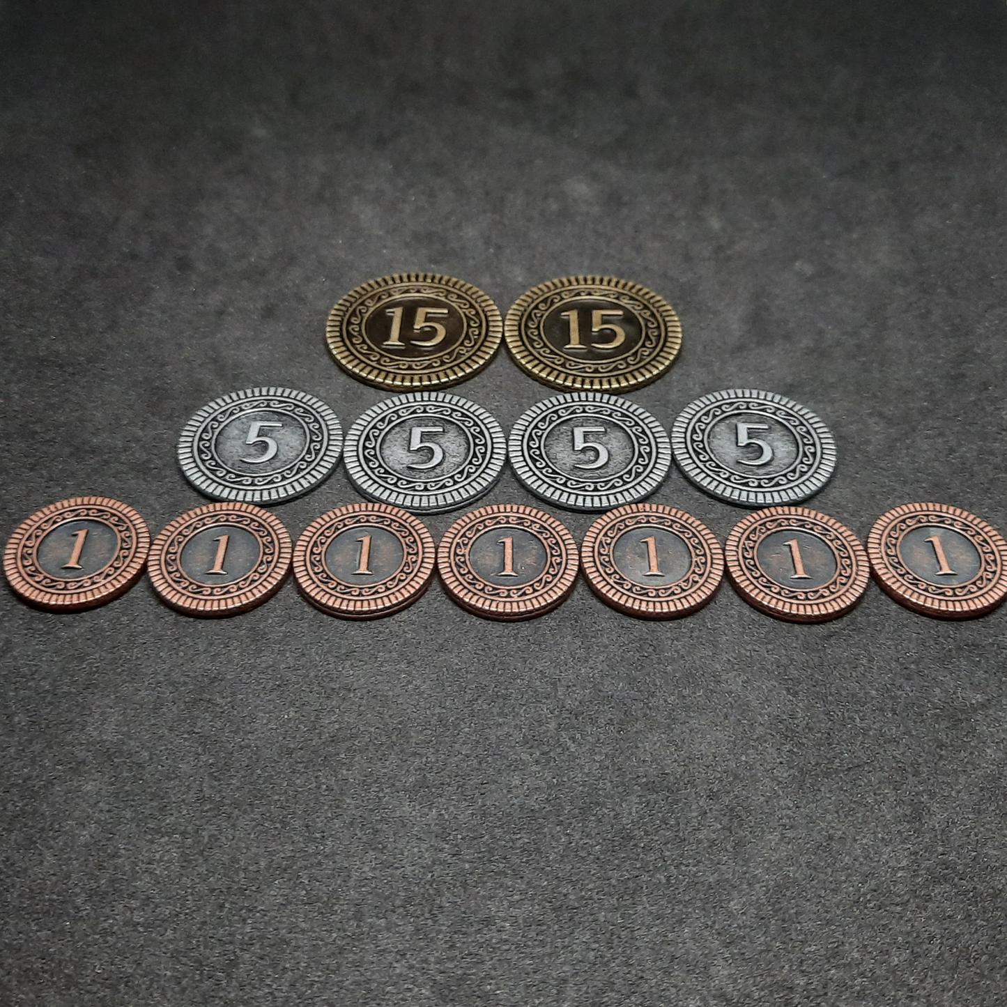 Set of bronze, silver and gold metal coins of value 1, 5 and 15 for board games