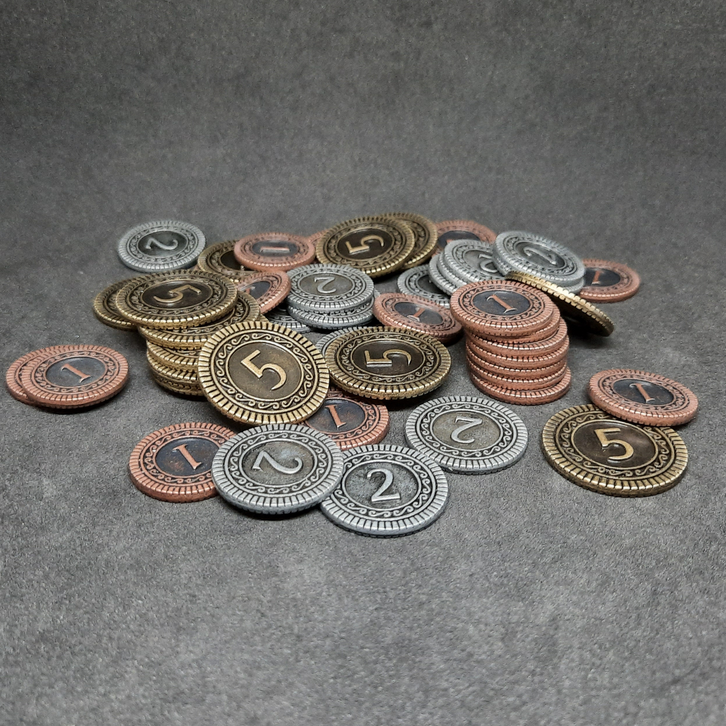 Set of bronze, silver and gold metal coins of value 1, 2 and 5 for board games