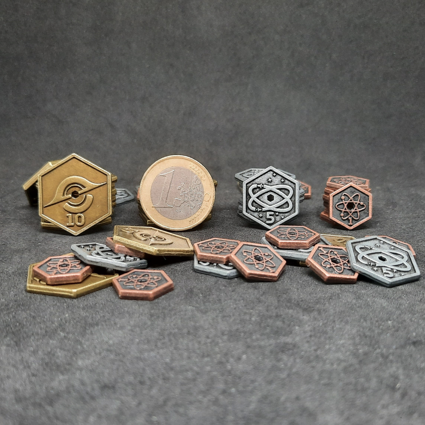 Set of spatial metal coins of value 1, 5 and 10 for board games, hexagonal shape