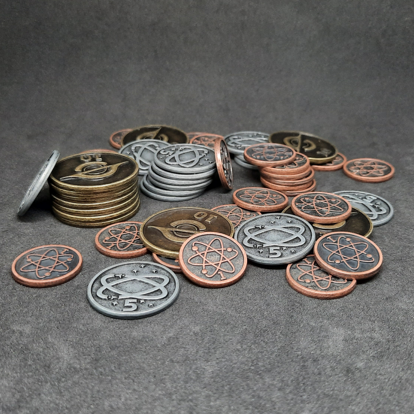 Set of bronze, silver and gold spatial metal coins of value 1, 5 and 10 for board games