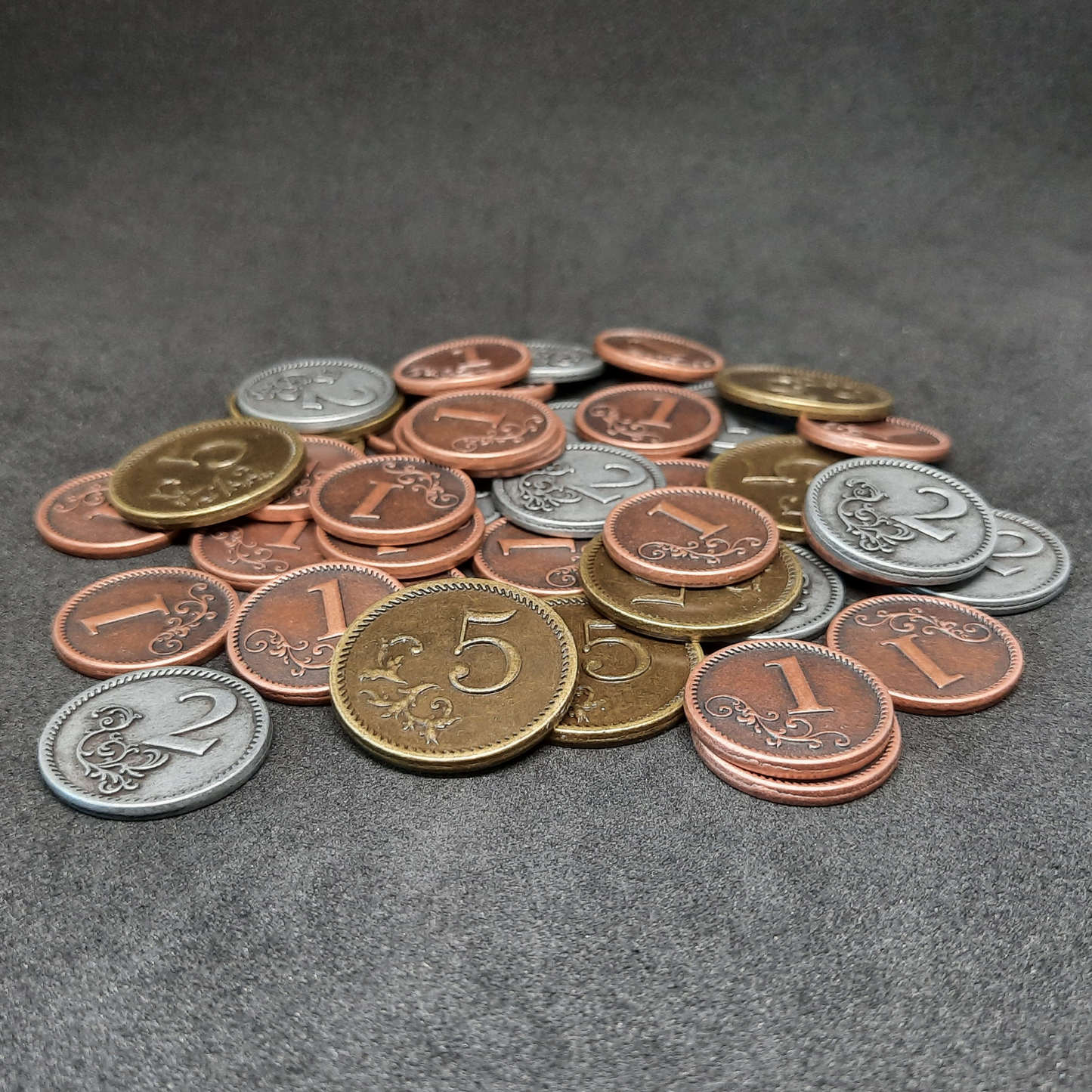 Set of bronze, silver and gold metal coins of value 1, 2, and 5 for board games