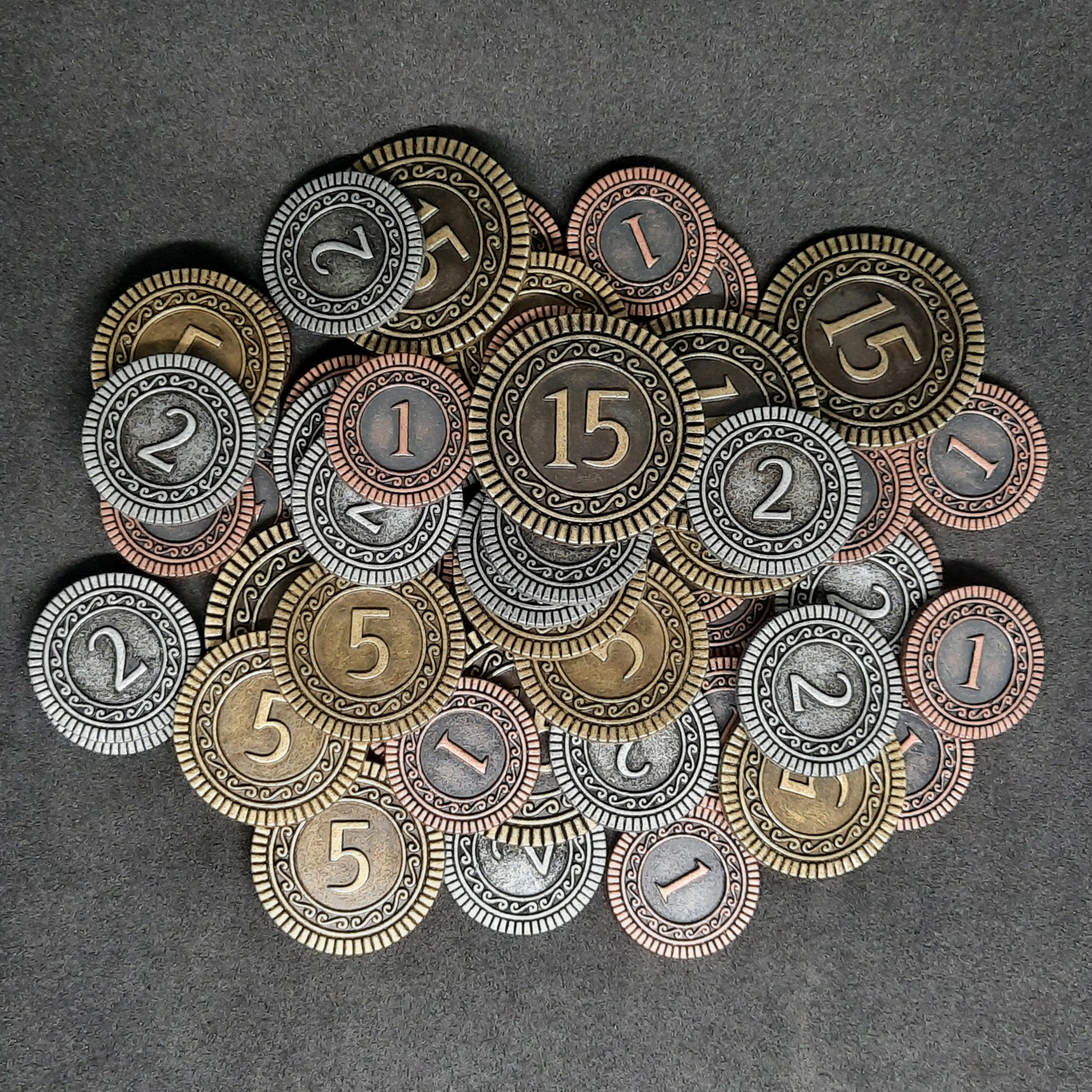 Set of bronze, silver and gold metal coins of value 1, 2, 5 and 15 for board games