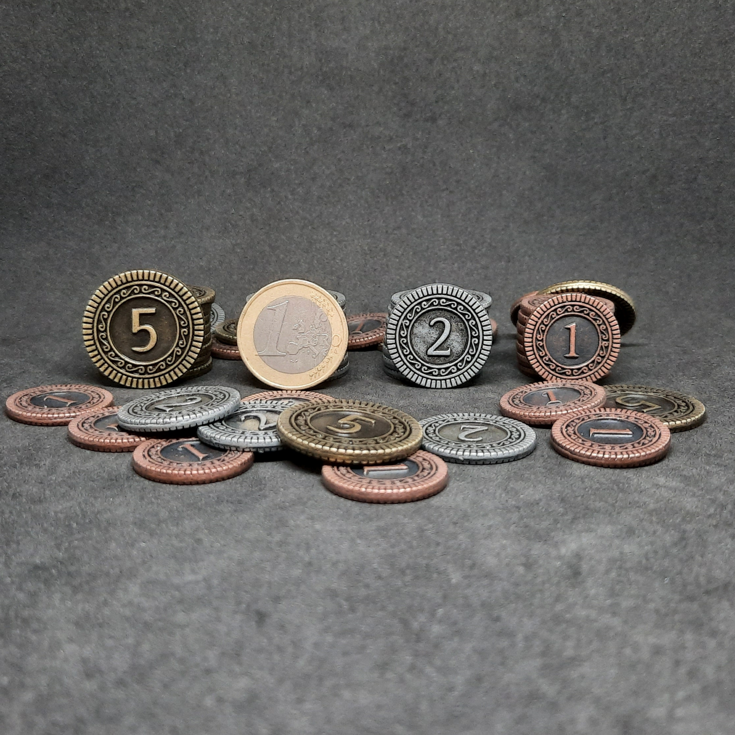 Set of bronze, silver and gold metal coins of value 1, 2 and 5 for board games