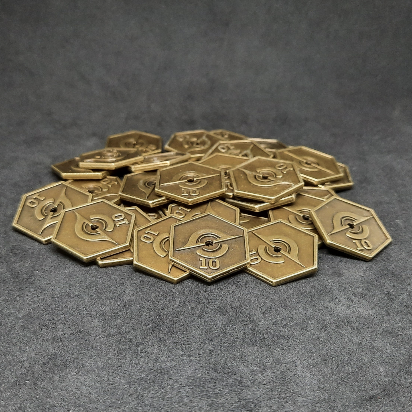 Gold spatial metal coins of value 10 for board games, hexagonal shape