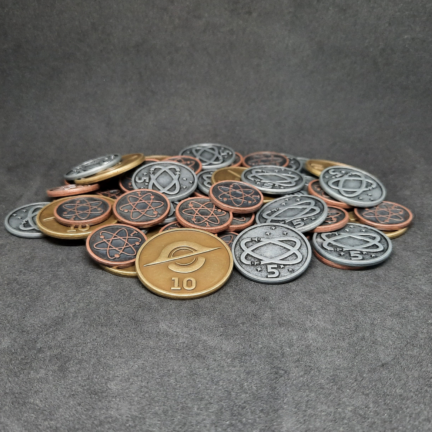 Set of bronze, silver and gold spatial metal coins of value 1, 5 and 10 for board games