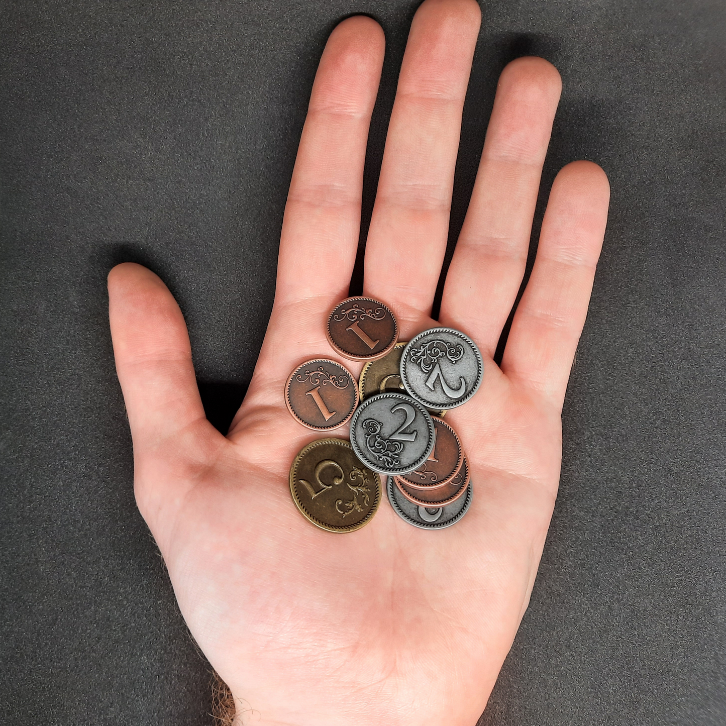 Set of bronze, silver and gold metal coins of value 1, 2 and 5 for board games