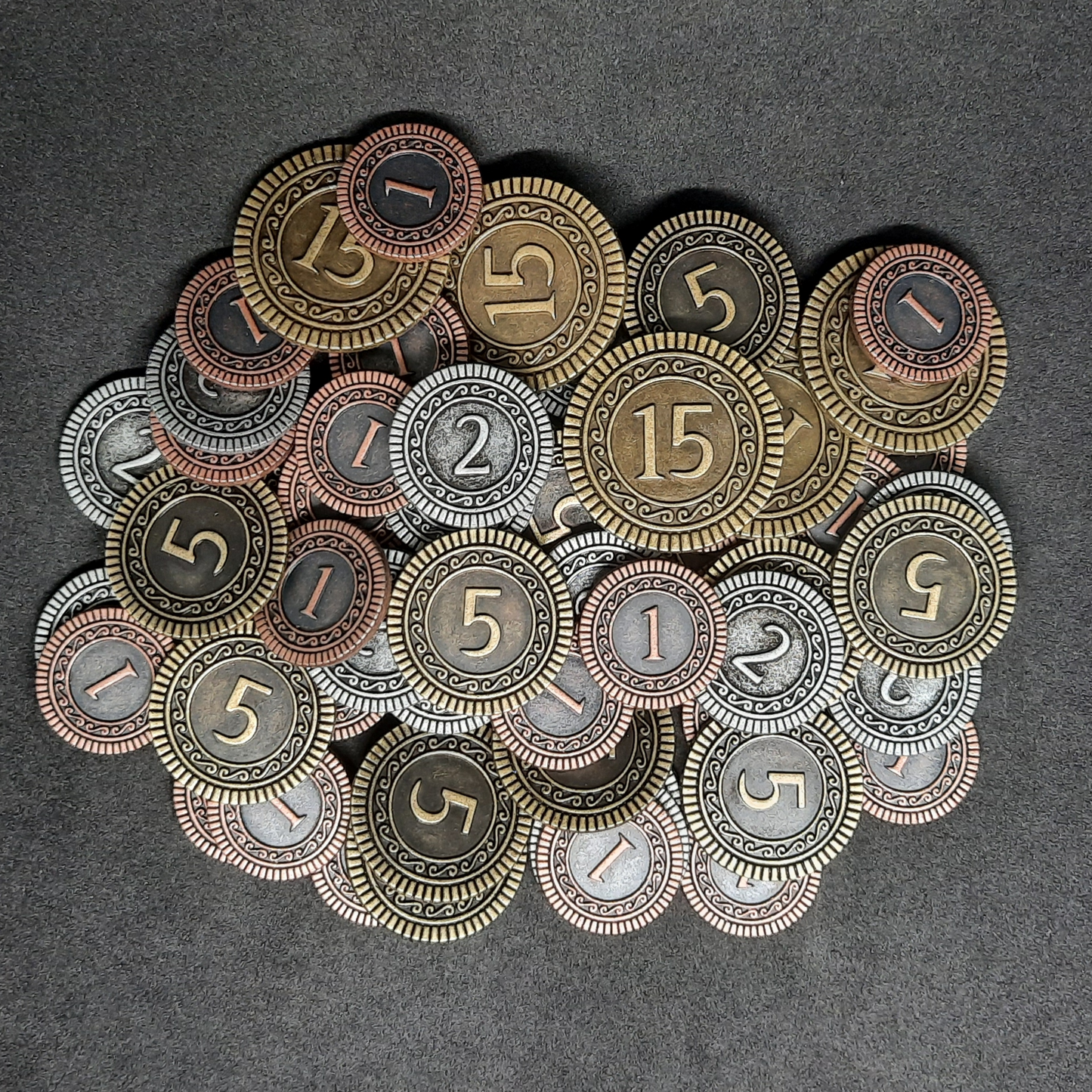 Set of bronze, silver and gold metal coins of value 1, 2, 5 and 15 for board games