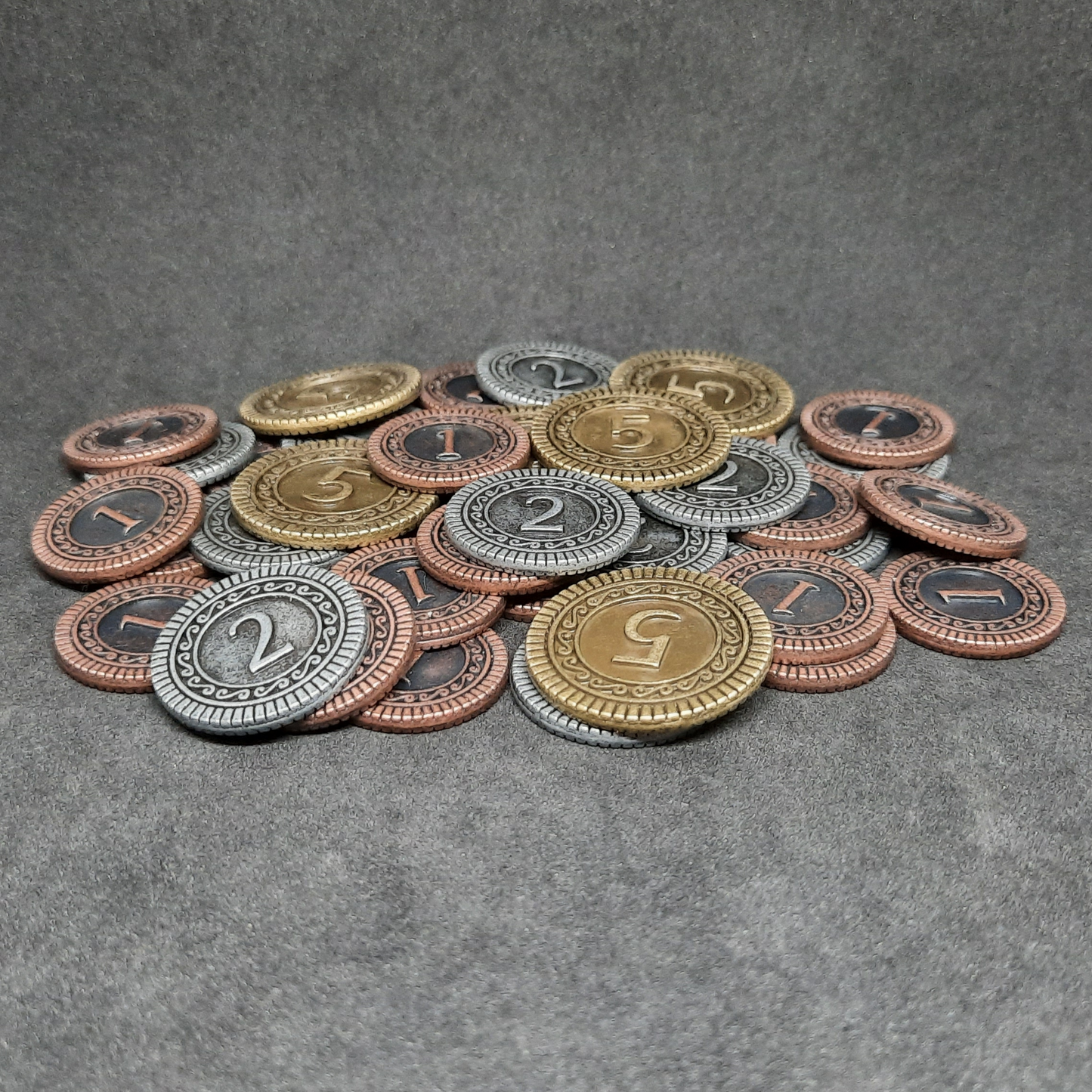 Set of bronze, silver and gold metal coins of value 1, 2 and 5 for board games