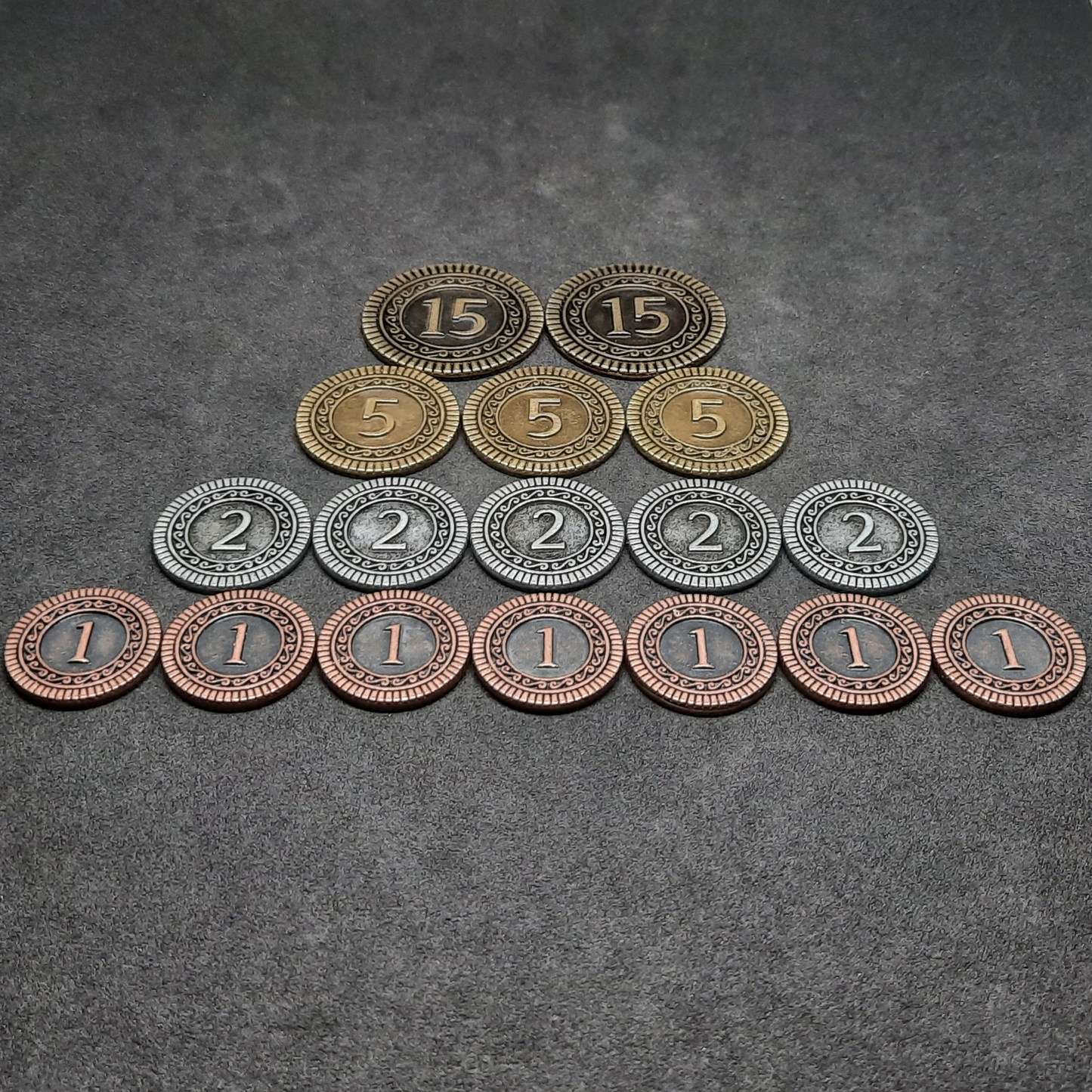 Set of bronze, silver and gold metal coins of value 1, 2, 5 and 15 for board games