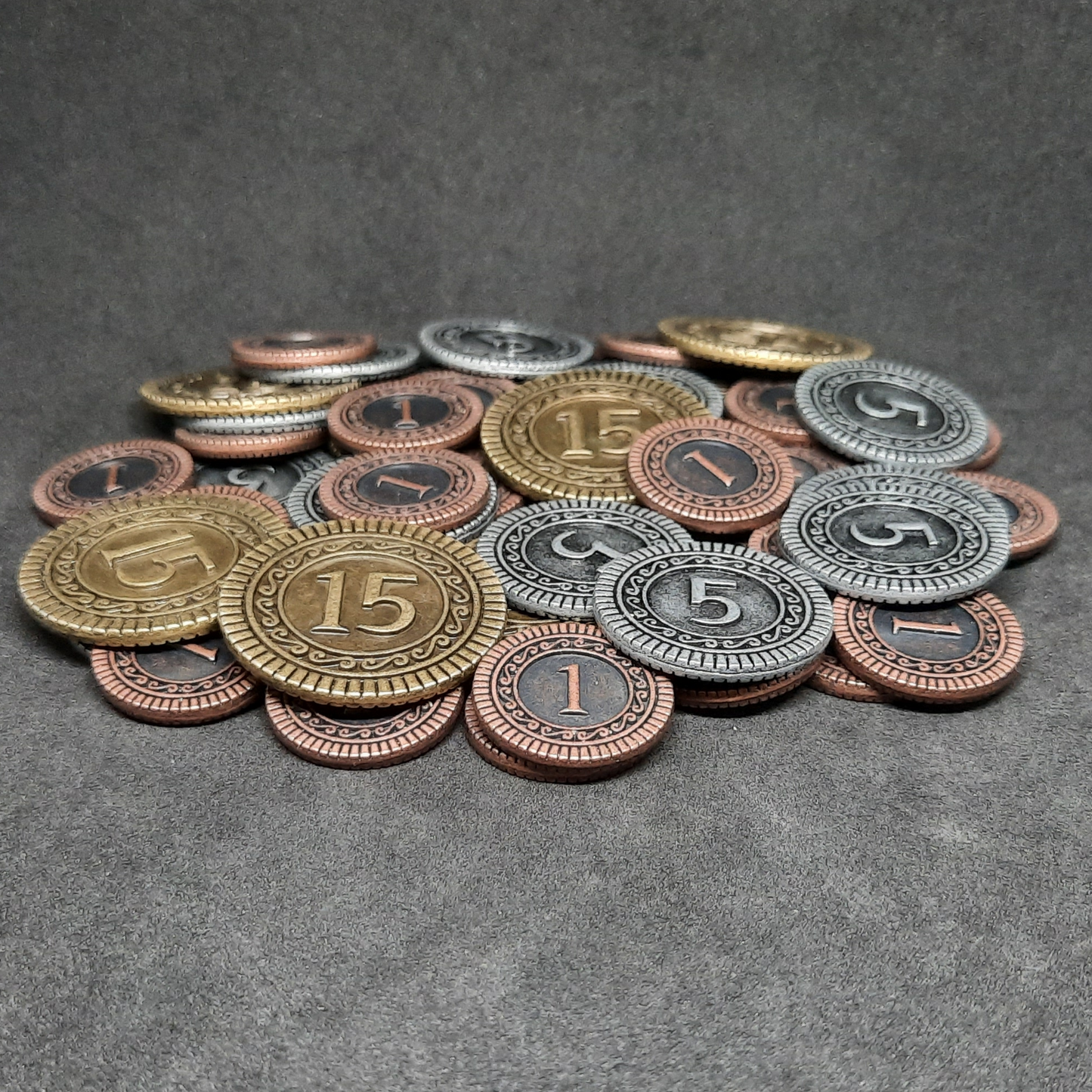 Set of bronze, silver and gold metal coins of value 1, 5 and 15 for board games