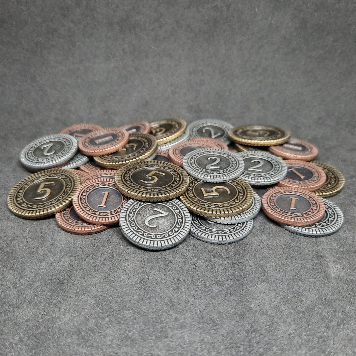 Set of bronze, silver and gold metal coins of value 1, 2 and 5 for board games