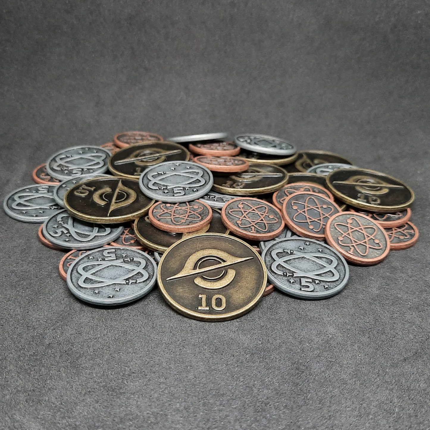 Set of bronze, silver and gold spatial metal coins of value 1, 5 and 10 for board games