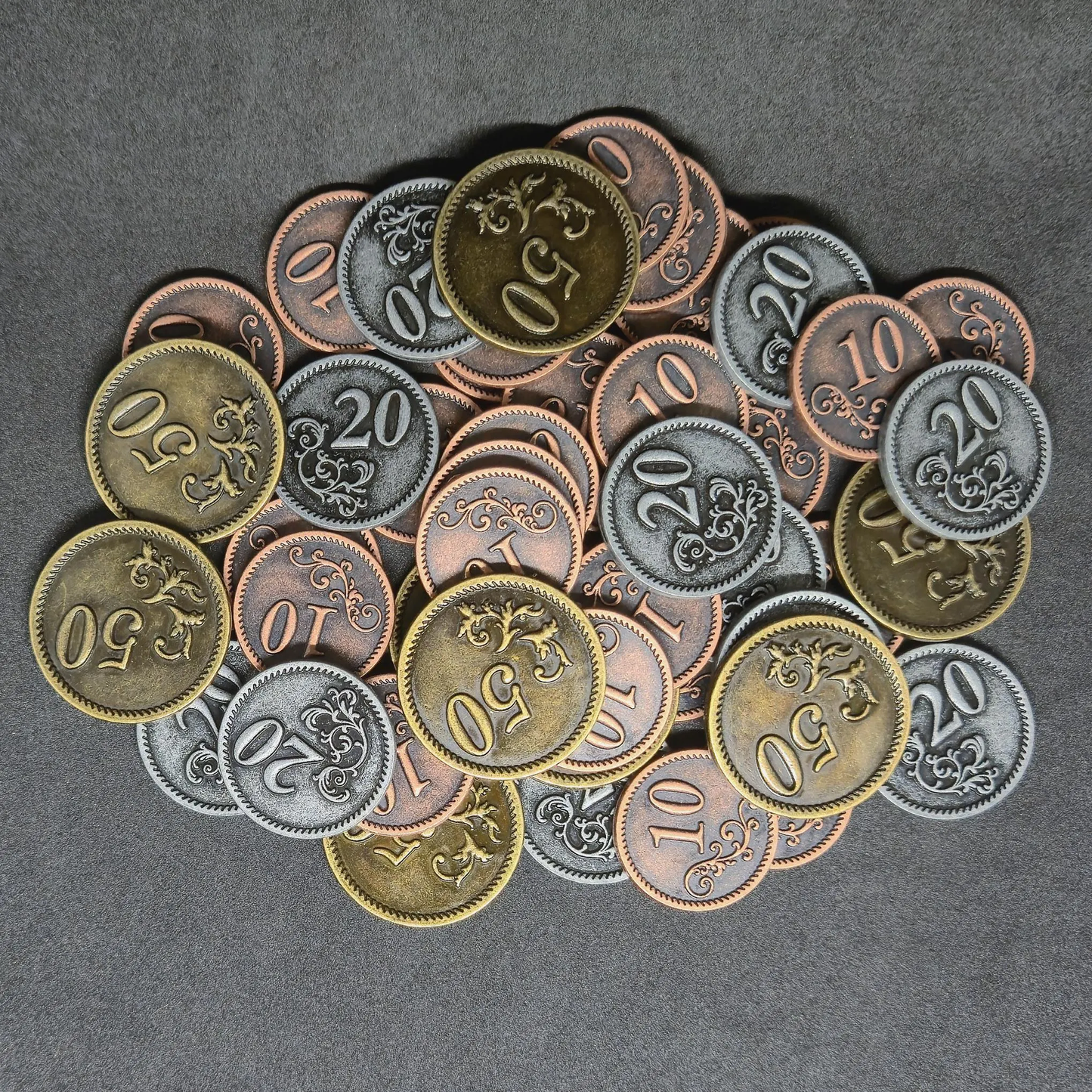 Set of bronze, silver and gold metal coins of value 10, 20, and 50 for board games