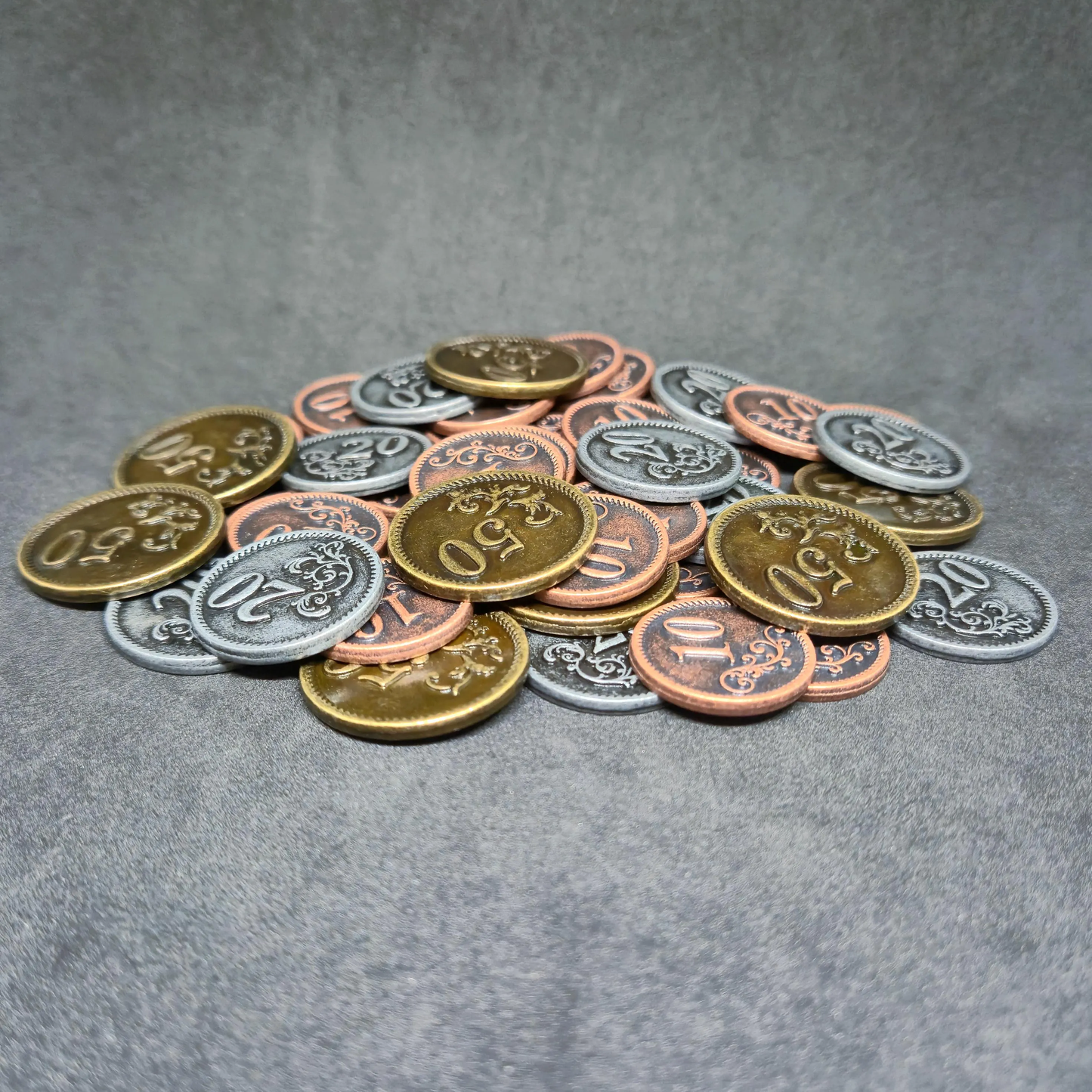 Set of bronze, silver and gold metal coins of value 10, 20, and 50 for board games