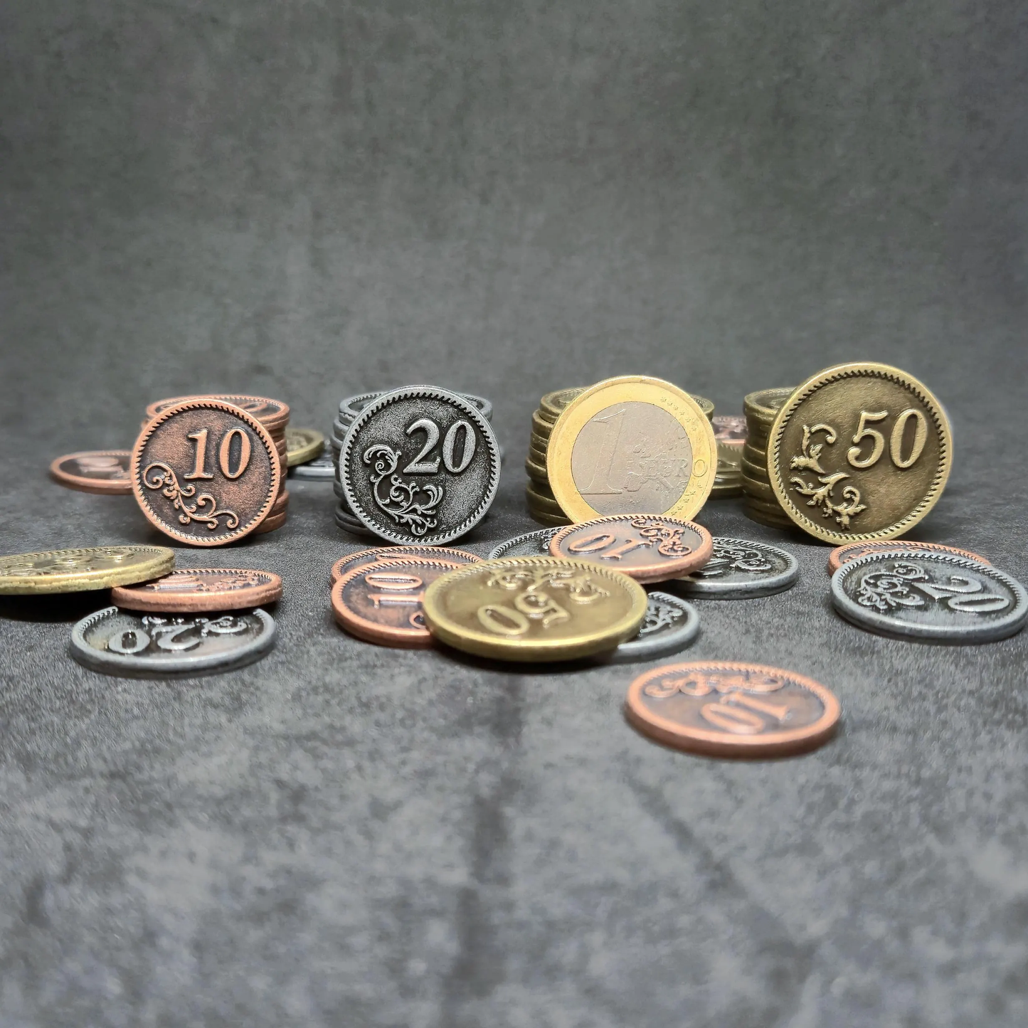 Set of bronze, silver and gold metal coins of value 10, 20, and 50 for board games