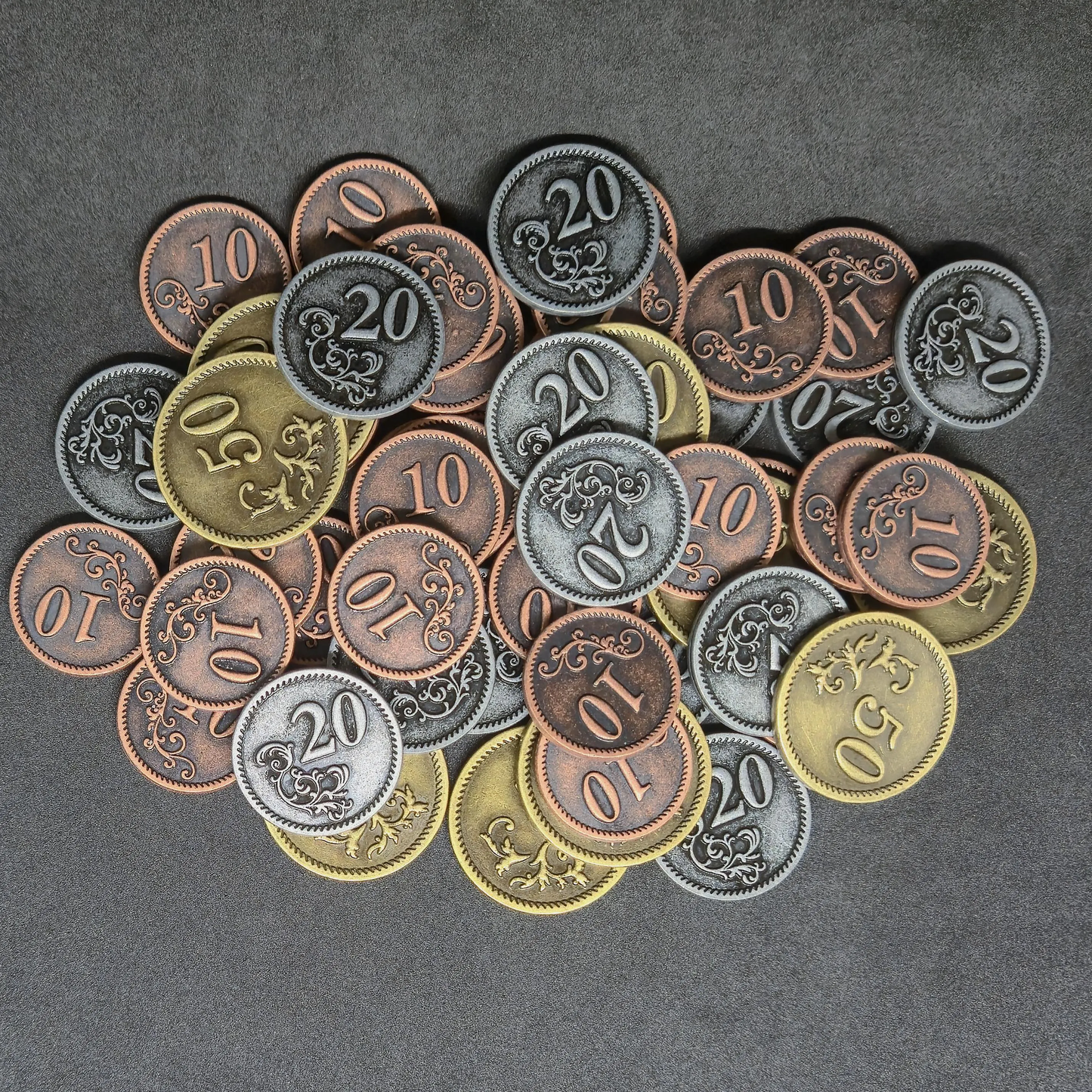 Set of bronze, silver and gold metal coins of value 10, 20, and 50 for board games